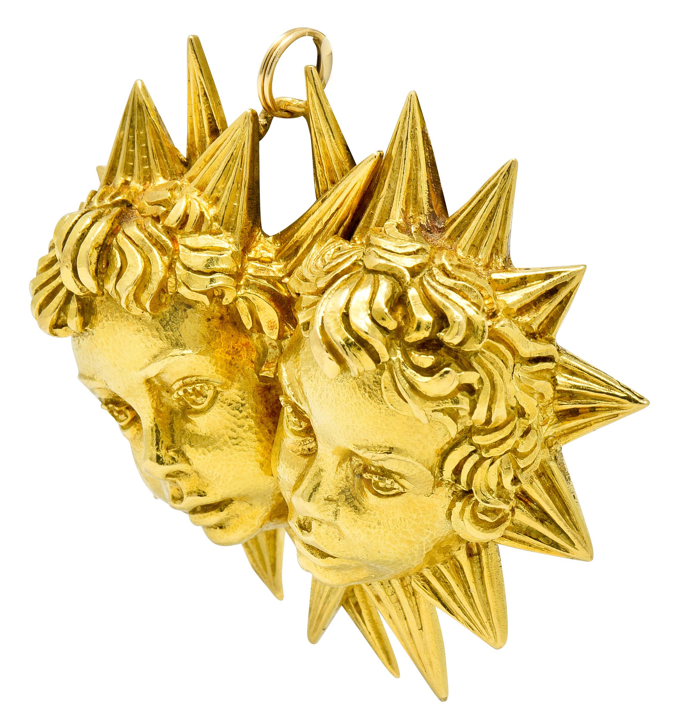 Substantial pendant designed as two highly rendered cherubic faces - symbolizing Gemini zodiac

With scrolled curls and detailed facial features, exhibiting a dimpled finish

Surrounded by a deeply ridged starburst motif with overlapping pointed