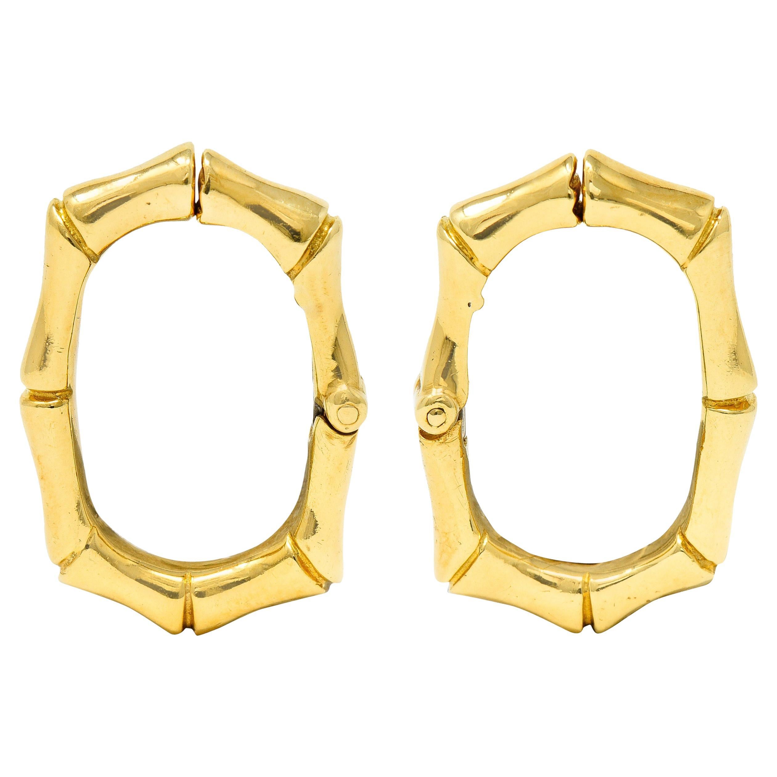 Ear-clip earrings are designed as oval shaped hoop with notched bamboo motif throughout

Featuring high polished gold

Completed by concealed hinged ear-clip

Stamped 18k for 18 karat gold

With maker's mark for David Webb

Circa: 20th