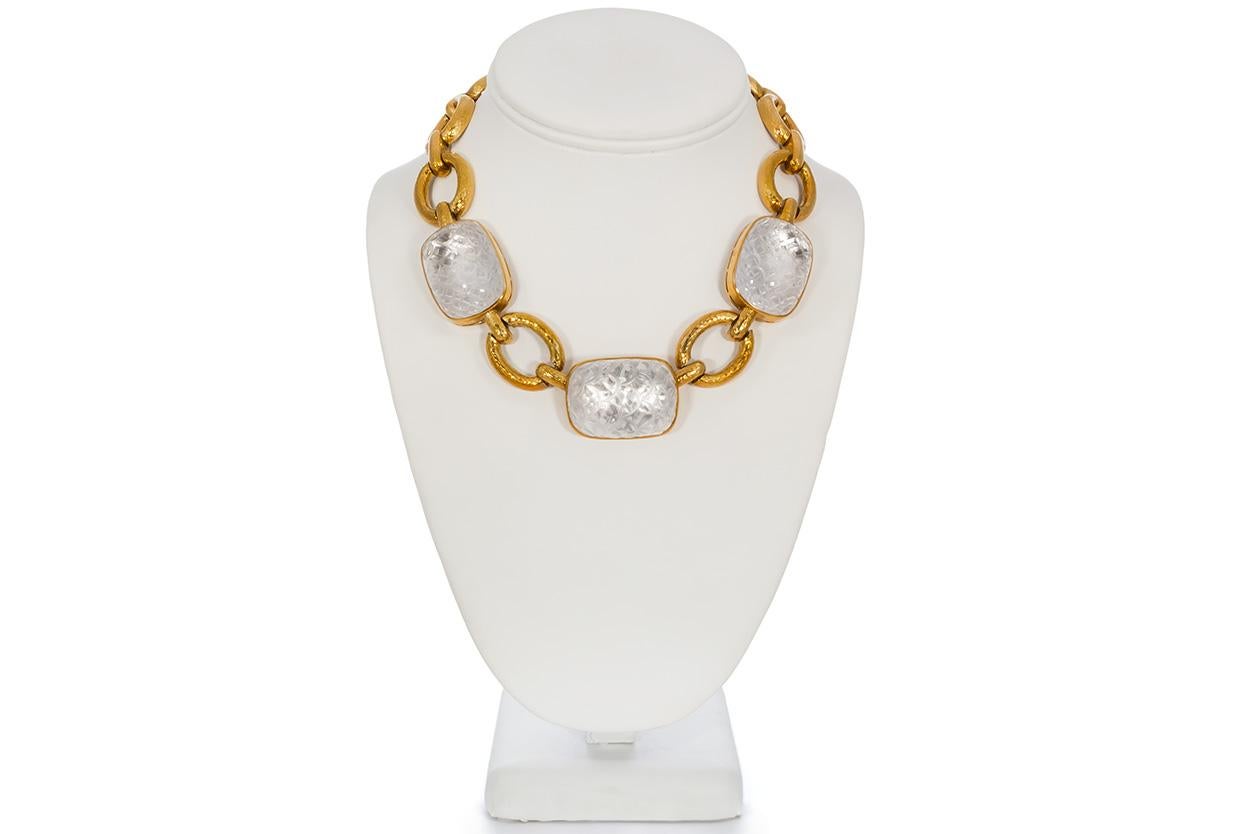 We are pleased to present this David Webb Vintage 18k Yellow Gold & Rock Crystal Set. This classic David Webb jewelry set features a stunning necklace and ear clips fashioned from 18k yellow gold and carved rock crystal. The links of the necklace