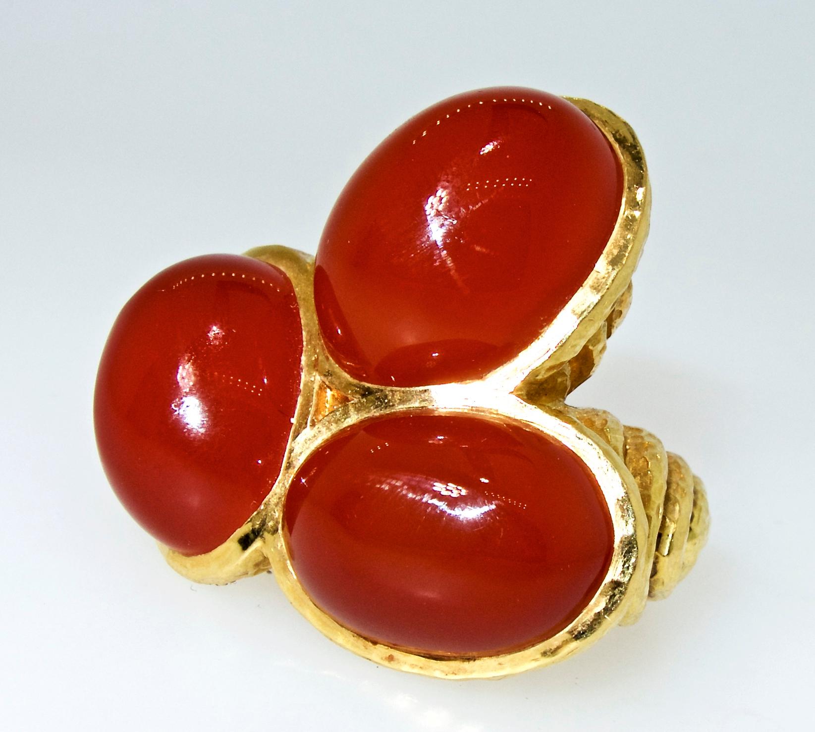 David Webb vintage unusual ring in 18K gold and centering in an 3 carnelian stones the largest measuring 20 by 15 mm.  The deep butterscotch color carnelian stones are set in an asymmetric, unpredictable design that is innovative even for the