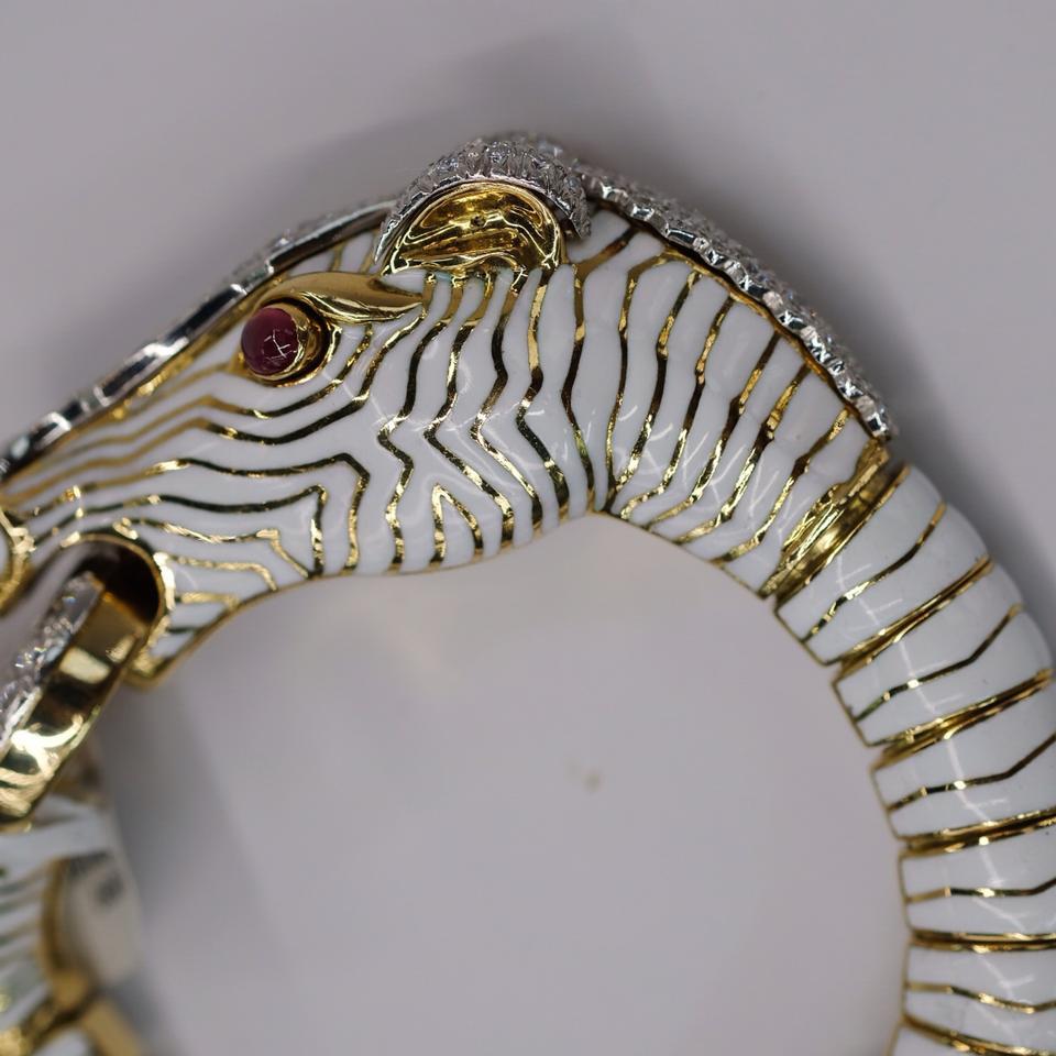 David Webb - Bracelet diamant rubis émail or platine cheval blanc

Impressionnant bracelet cheval en or 18k et platine émaillé blanc, réalisé par David Webb pour la collection Animal Kingdom. Le bracelet est serti d'environ 4,00ctw de diamants GH/VS