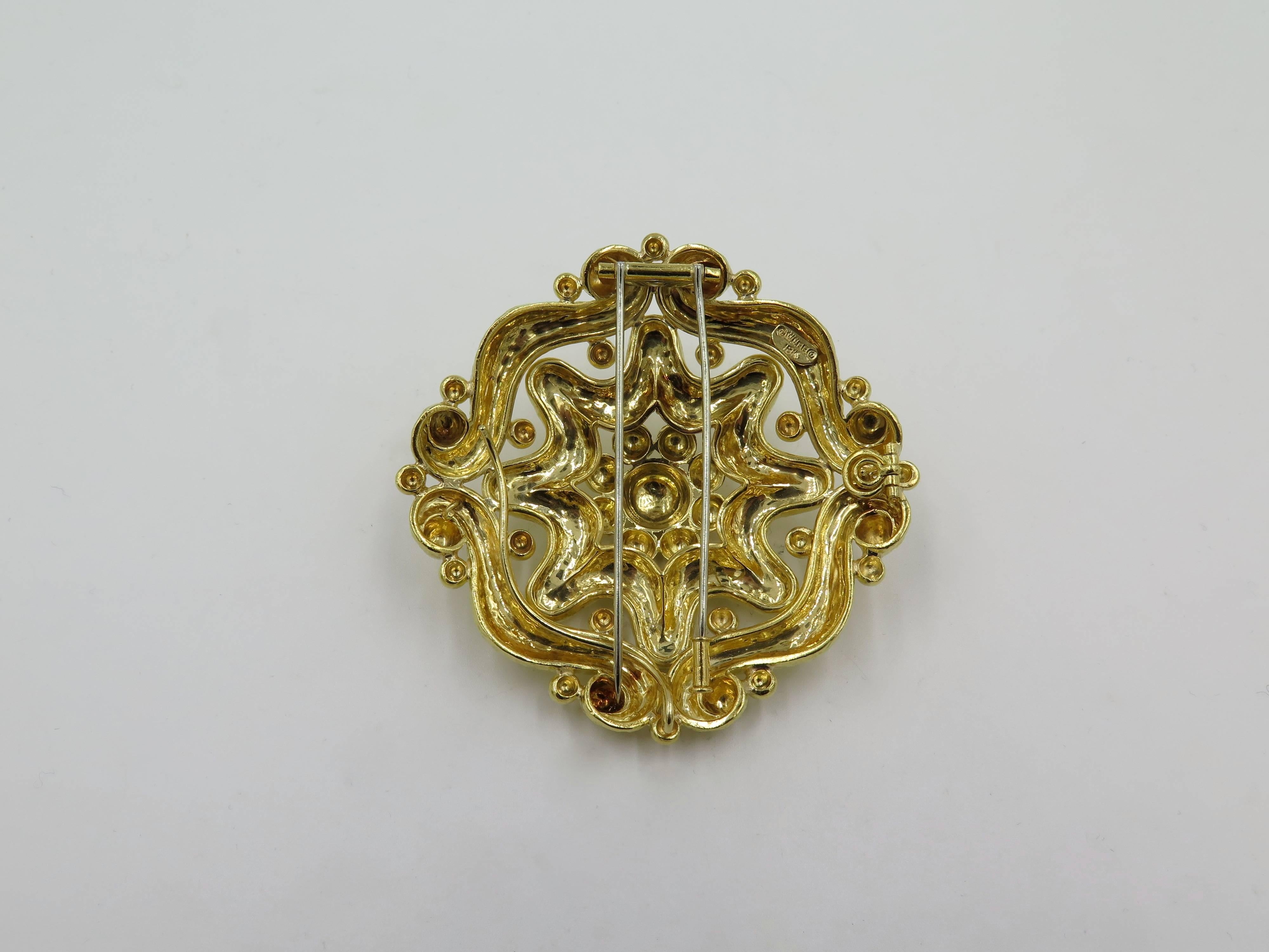 An 18 karat yellow gold brooch. David Webb. Designed as a hammed gold openwork plaque of stylized floral design, enhanced by gold beads. Diameter is approximately 2 1/2 inches. Gross weight is approximately 65.6 grams