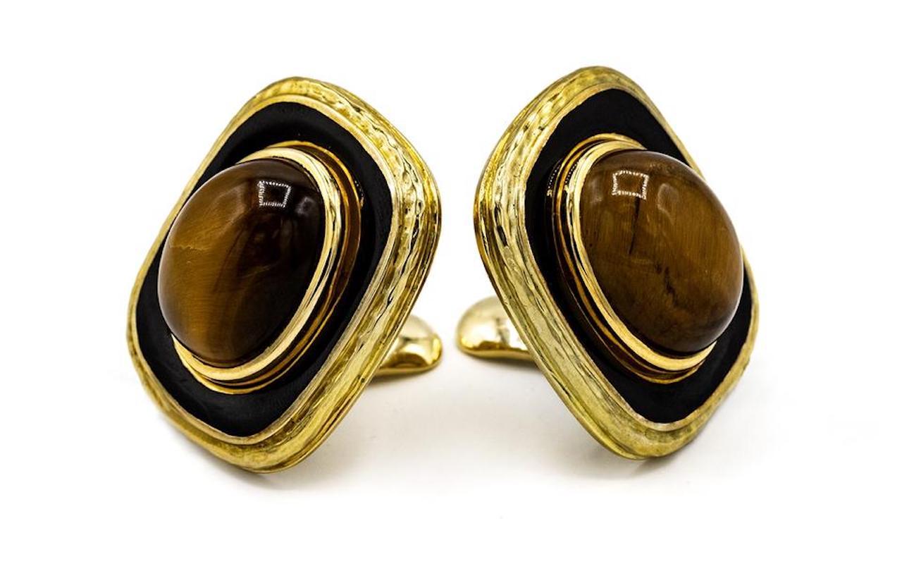 Yellow gold cushion shape ear clips by David Webb. Crafted in 18k yellow gold, mounted with cat's eye oval cabochon, framed in gold with a touch of black enamel.

Measurements: 30mm x 27mm
Closure: Omega Clip-On