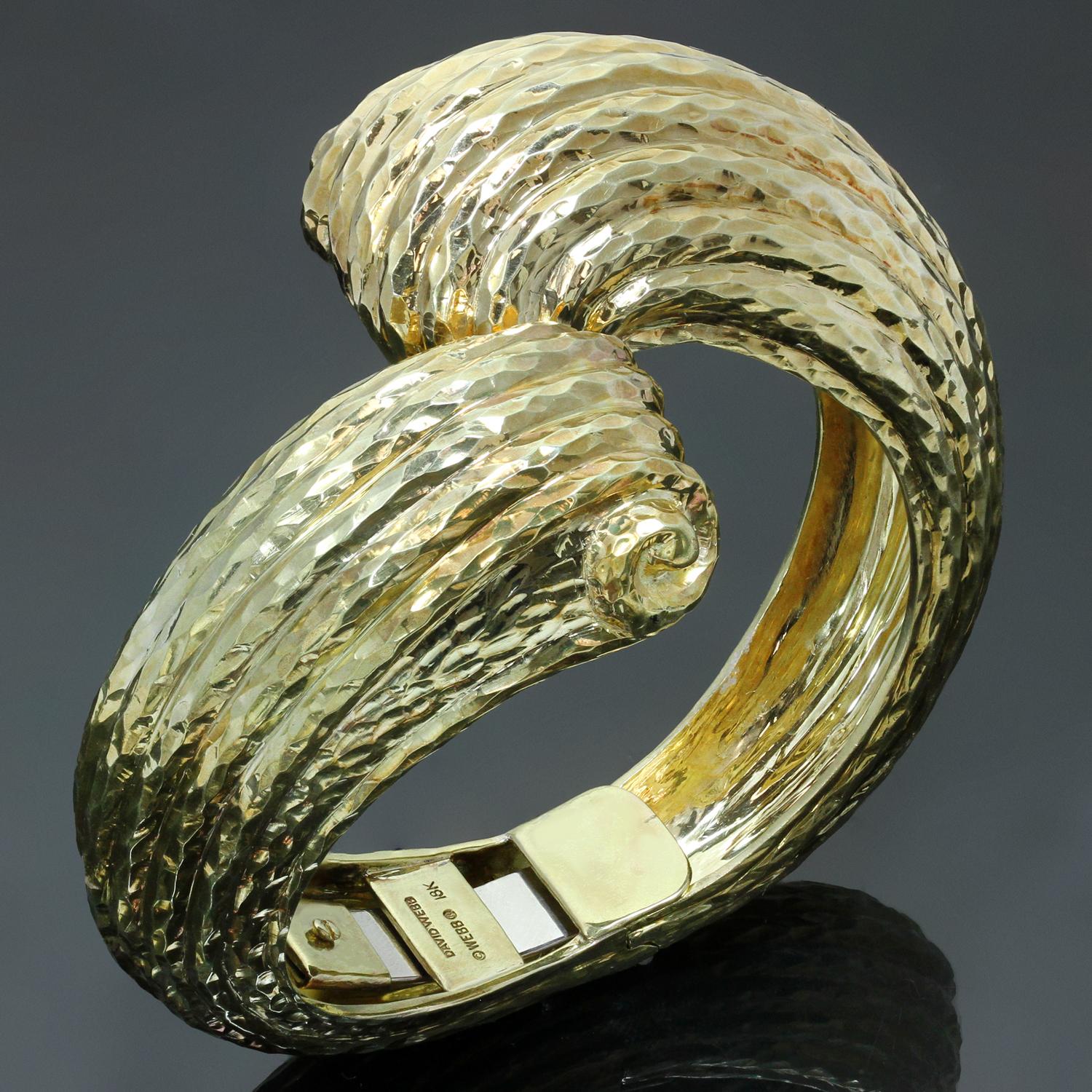This chic and fabulous David Webb crossover cuff bracelet features a hammered texture crafted out of 18k solid yellow gold. Made in United States circa 1980s. Measurements: 2.04