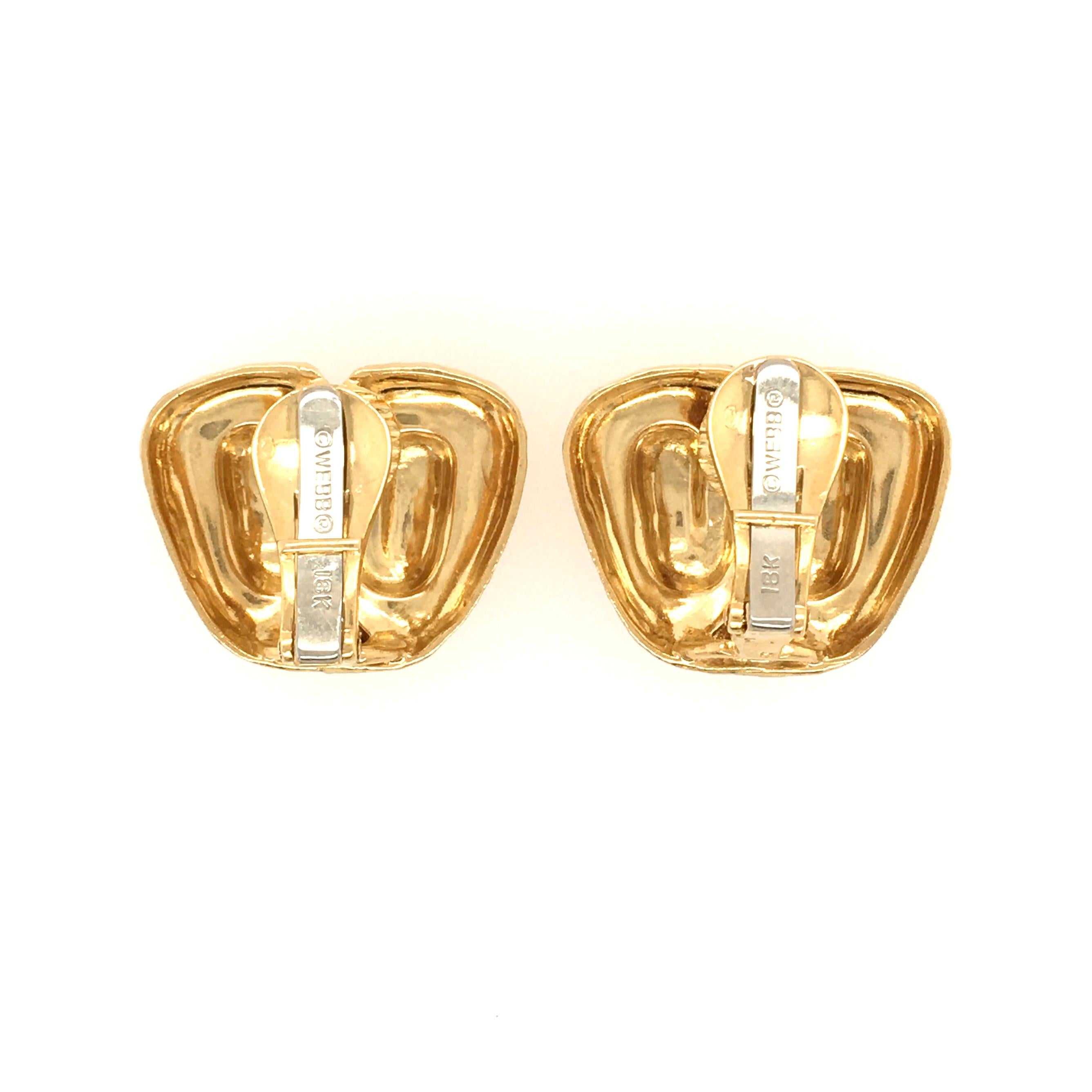 A pair of 18 karat yellow gold earrings with clip backs. David Webb. The hammered finish irregular shaped earrings measure 15/16 inch wide and 12/16 inch from top to bottom. The clips are stamped © WEBB ®.  Gross weight is approximately 22.55 grams.