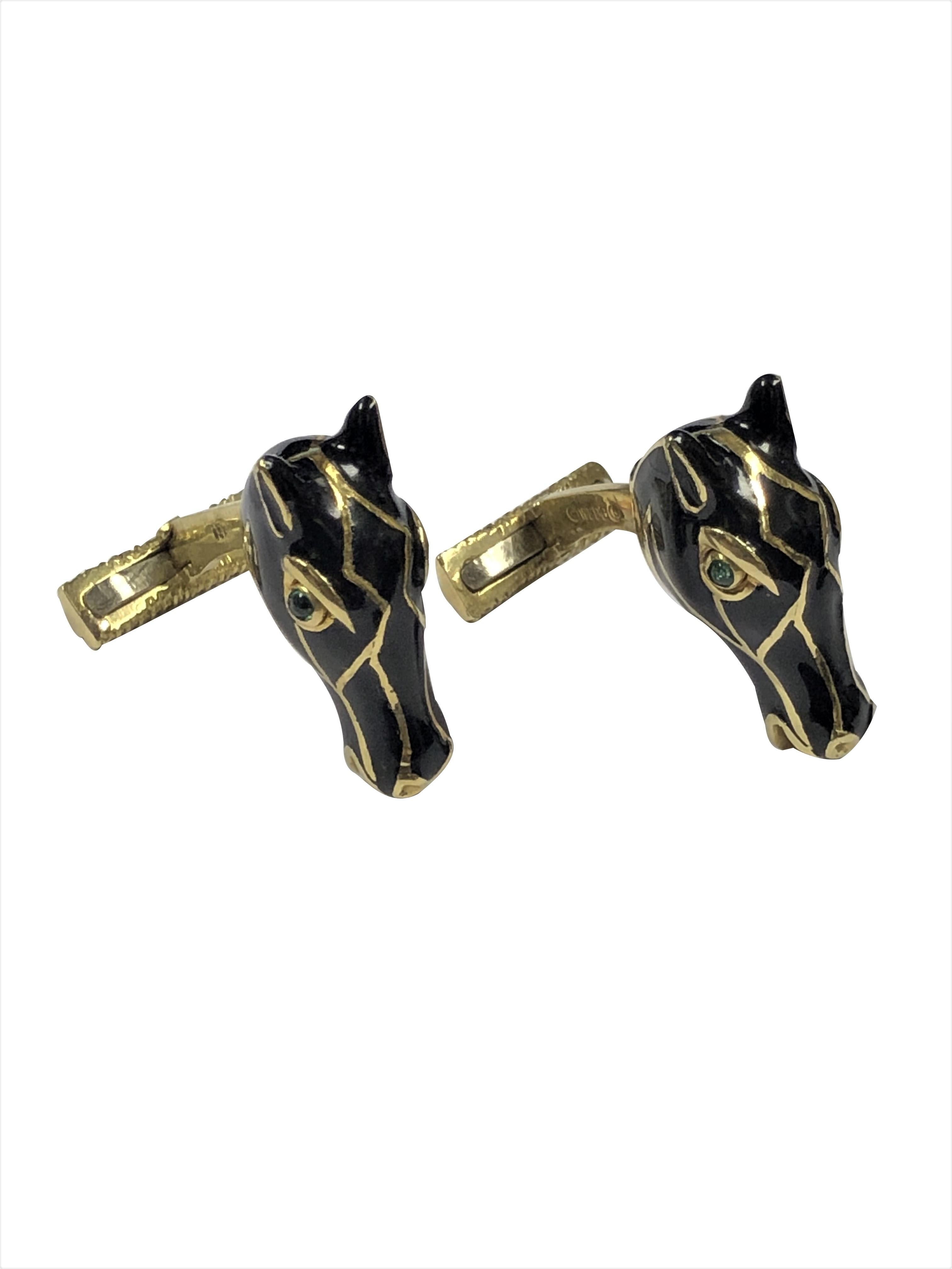 Circa 1990 David Webb 18K Yellow Gold Horse Head Cufflinks, measuring 1 inch in length and 3/8 inch wide, these are solid with a good weight of 27.2 Grams. Nicely detailed in Black enamel and having Cabochon Emerald Eyes. Lever backs for easy on and