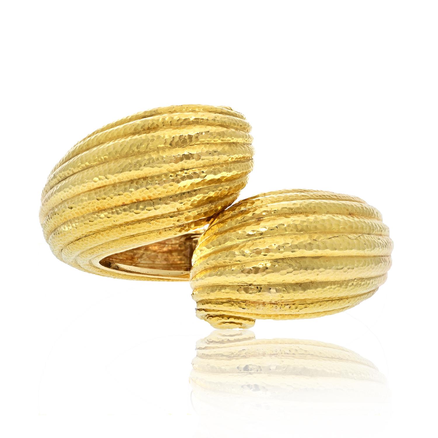 The exquisite David Webb 1970's 18 Karat Yellow Gold Fluted Hammered Scroll Vintage Cuff Bracelet, a true embodiment of elegance and artistry. 

This remarkable piece is crafted with precision and attention to detail, featuring fluted domed gold
