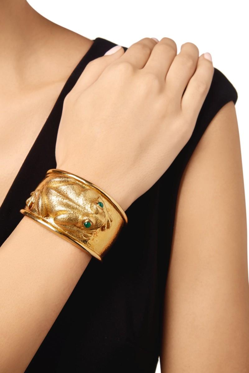GOLD AND EMERALD CUFF-BRACELET, DAVID WEBB

Of hinged design, composed of hammered gold and featuring a textured gold frog, set with cabochon emerald eyes, gross weight approximately 71 dwts, internal circumference 6 1/4  inches, signed Webb.
