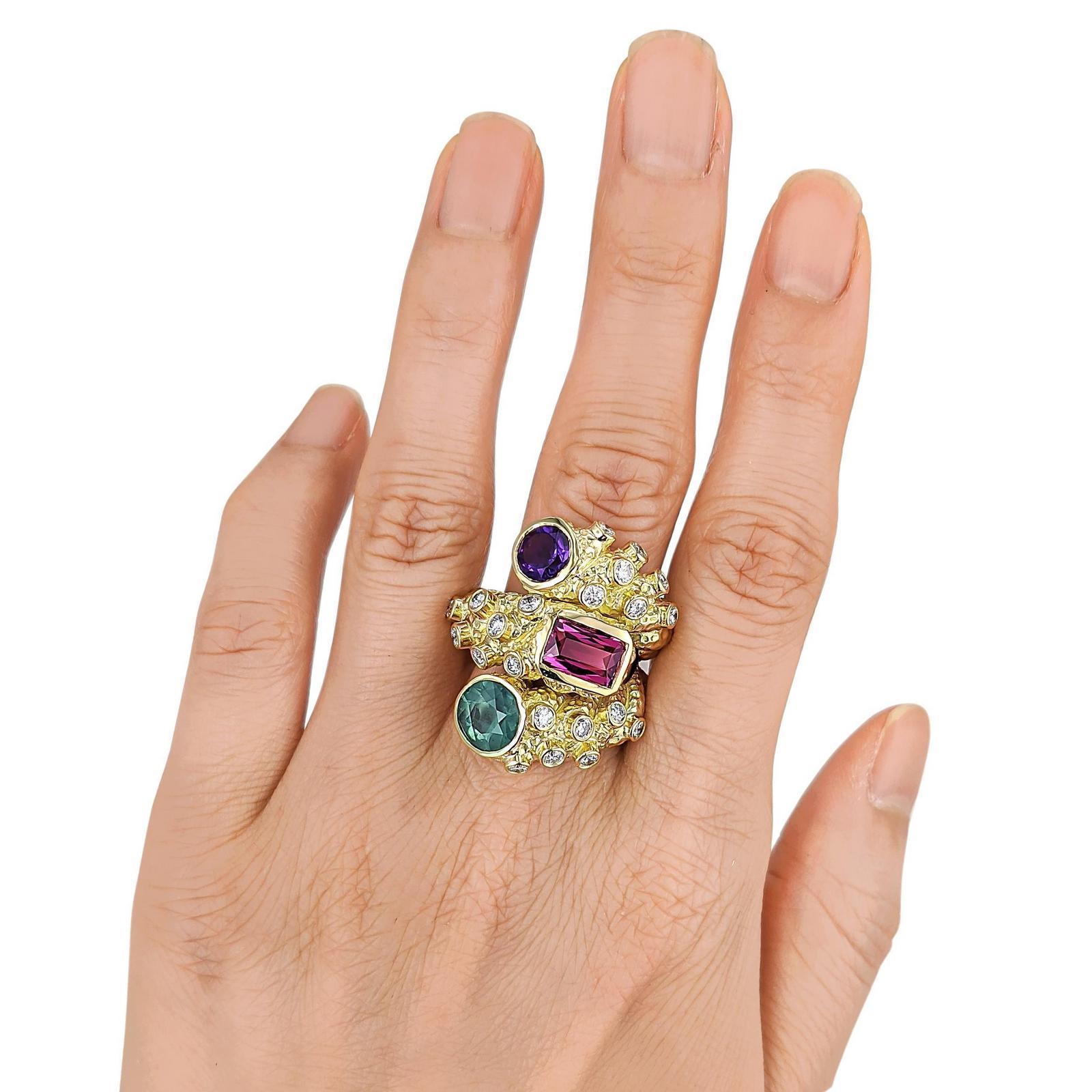 Crafted in 18K gold; set with round-cut diamonds, weighing a total of approximately 0.95 carat, most with F-G color and VS clarity; enhanced with round- and rectangular-cut multi-colored gemstones; measures 1-1/8 inch at widest section; ring size 7;