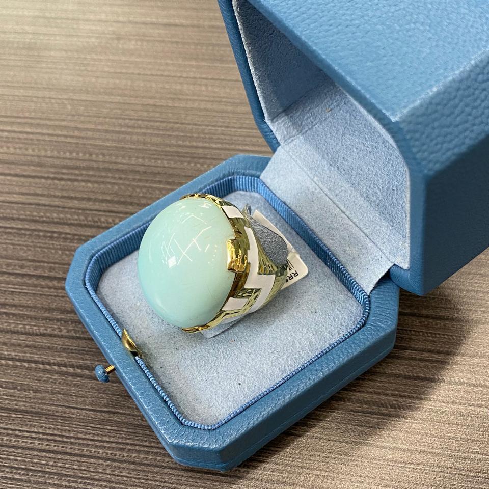 This lustrous and rare David Webb domed ring is mounted with glossy turquoise in hammer finished gold with white enamel details. Center stone is of a delicate dreamy blue color and we are certain it will catch lots of looks.

Material: Platinum &