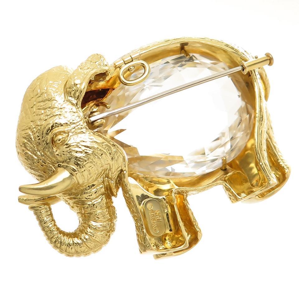 Circa 1990 David Webb 18K Yellow Gold Elephant Brooch, measuring 2 1/2 inch in length and 2 inches in height this piece of wearable sculpture is very detailed on all sides and weighs a total of 86.5 Grams. The center is set with a two-sided faceted