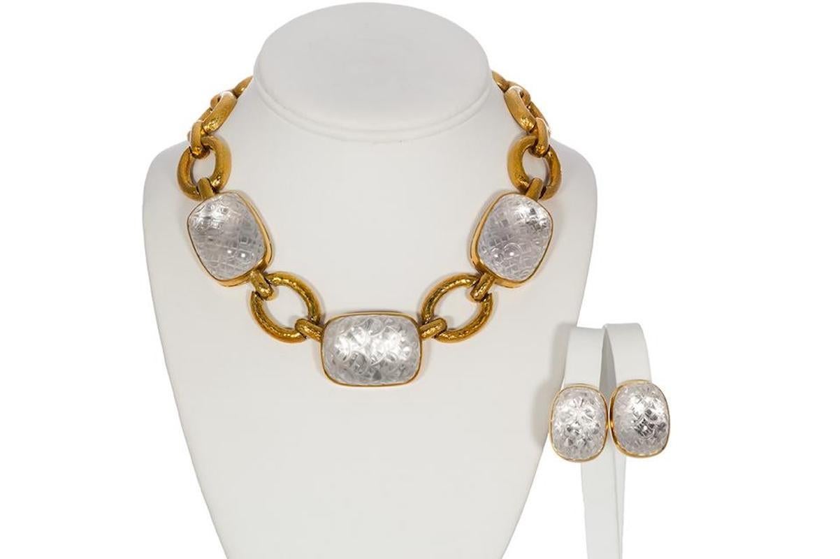 David Webb Vintage 18k Yellow Gold & Rock Crystal Set. This classic David Webb jewelry set features a stunning necklace and ear clips fashioned from 18k yellow gold and carved rock crystal. The links of the necklace have a hammered like texture to