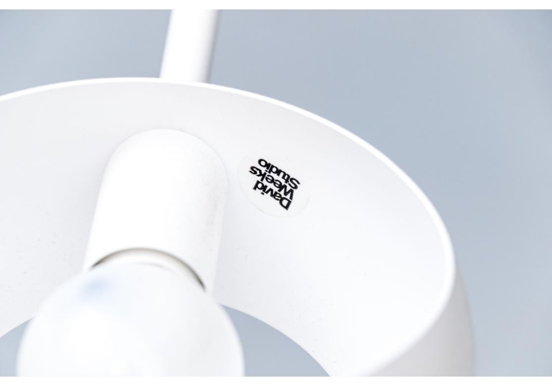 Un lampadario a sospensione bianco che presenta un interessante decentramento, ma perfettamente bilanciato. Il trio di pendenti Boi è formato da un unico livello con tre bracci adiacenti e contrappesati, ognuno dei quali è sormontato da un paralume