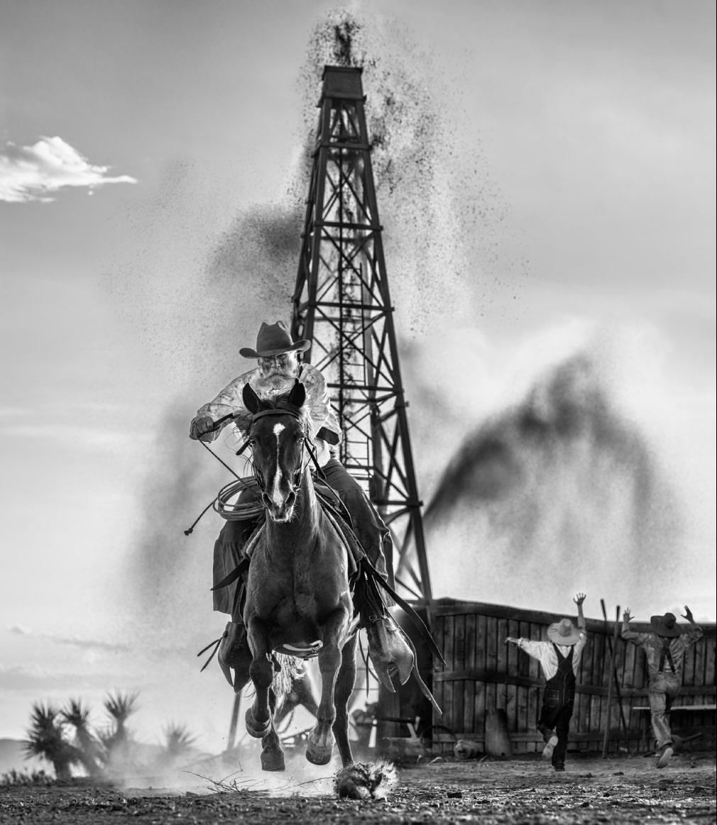 David Yarrow Figurative Photograph - 'Black Gold' - Man galopping in front of an oil farm, fine art photography, 2023
