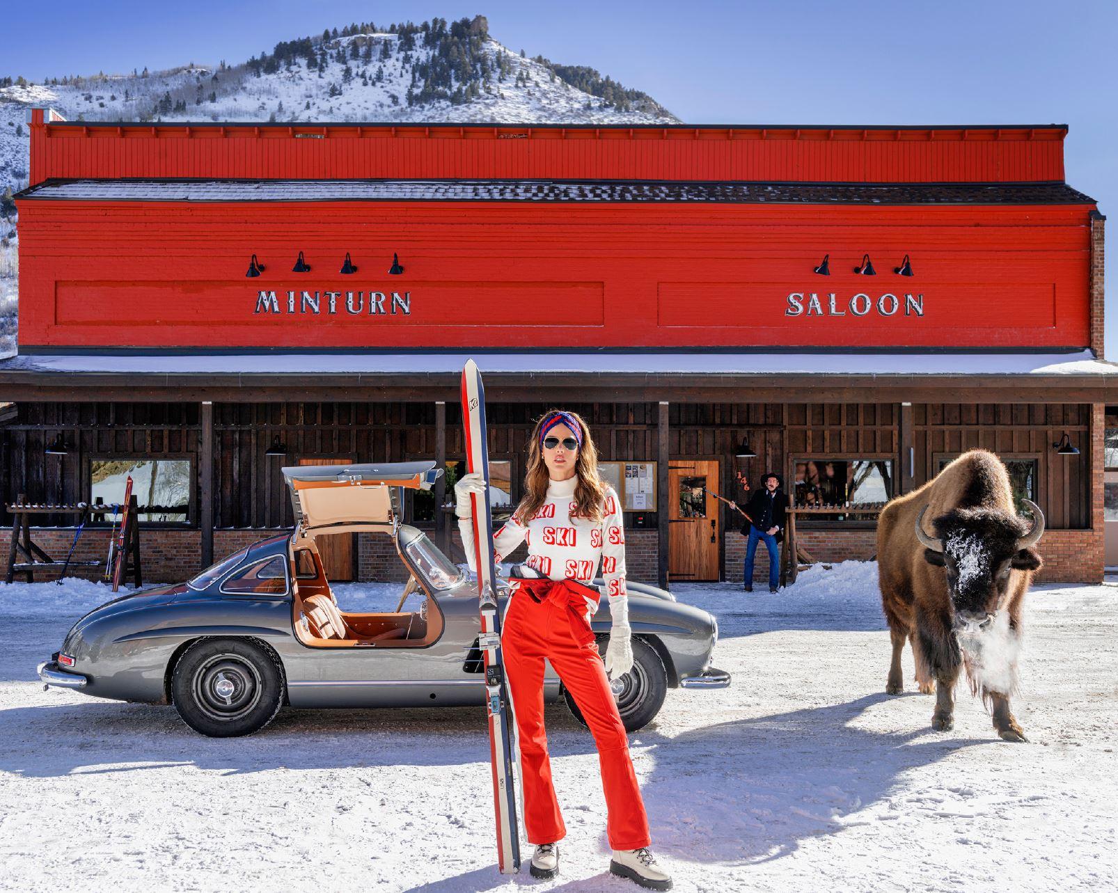 David Yarrow Figurative Photograph - Code Red - Model and Buffalo in front of red Saloon, fine art photography, 2024