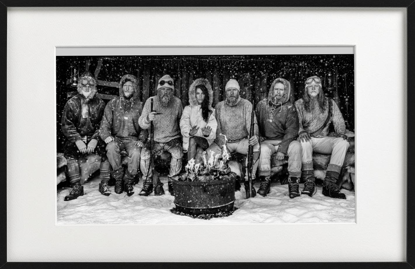 Ice Ice Baby - Model Brooks Nader with Polar Explorers Sitting Around Fireplace - Photograph by David Yarrow