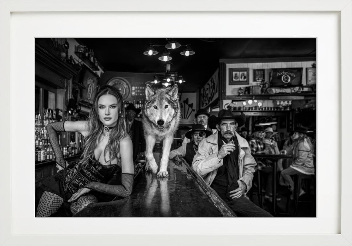 Kochevars, Crested Butte - Model and Wolf in old Bar, fine art photography, 2024 - Photograph by David Yarrow
