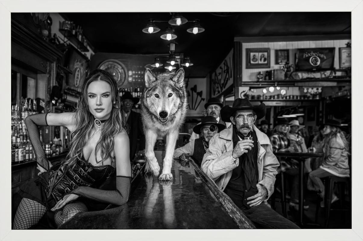 Kochevars, Crested Butte - Model and Wolf in old Bar, fine art photography, 2024 - Contemporary Photograph by David Yarrow