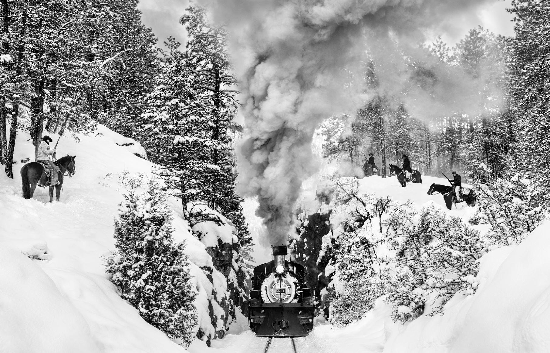 David Yarrow Figurative Photograph - 'Outlaws' - Cowboys ambushing historic train in snow, fine art photography, 2024