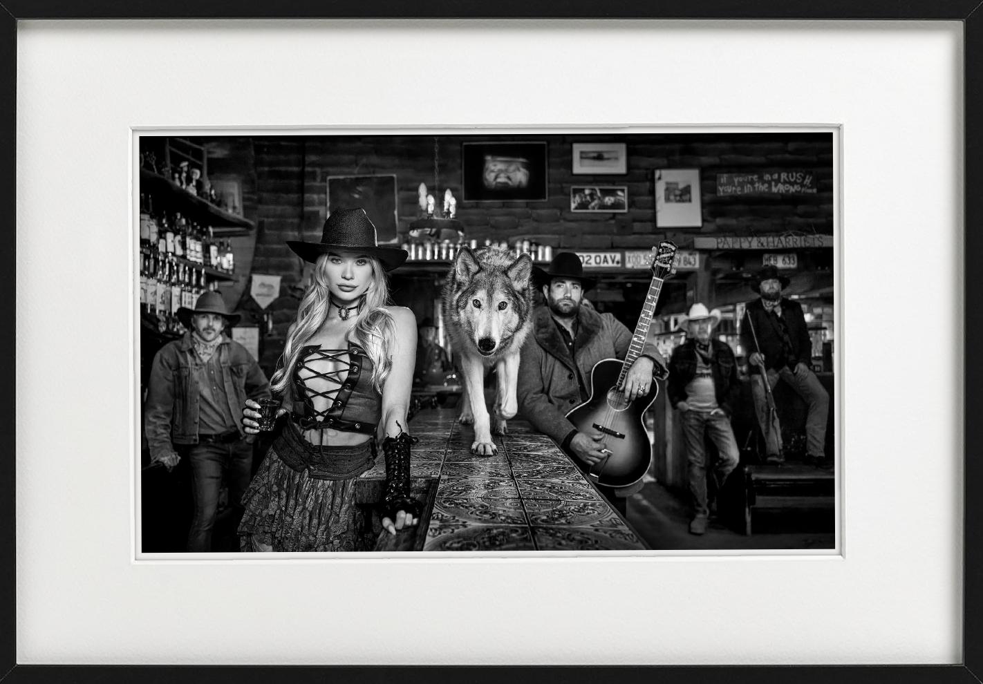 Pappy & Harriet's – Modell und Wolf in der alten Bar, Kunstfotografie, 2024 (Zeitgenössisch), Photograph, von David Yarrow