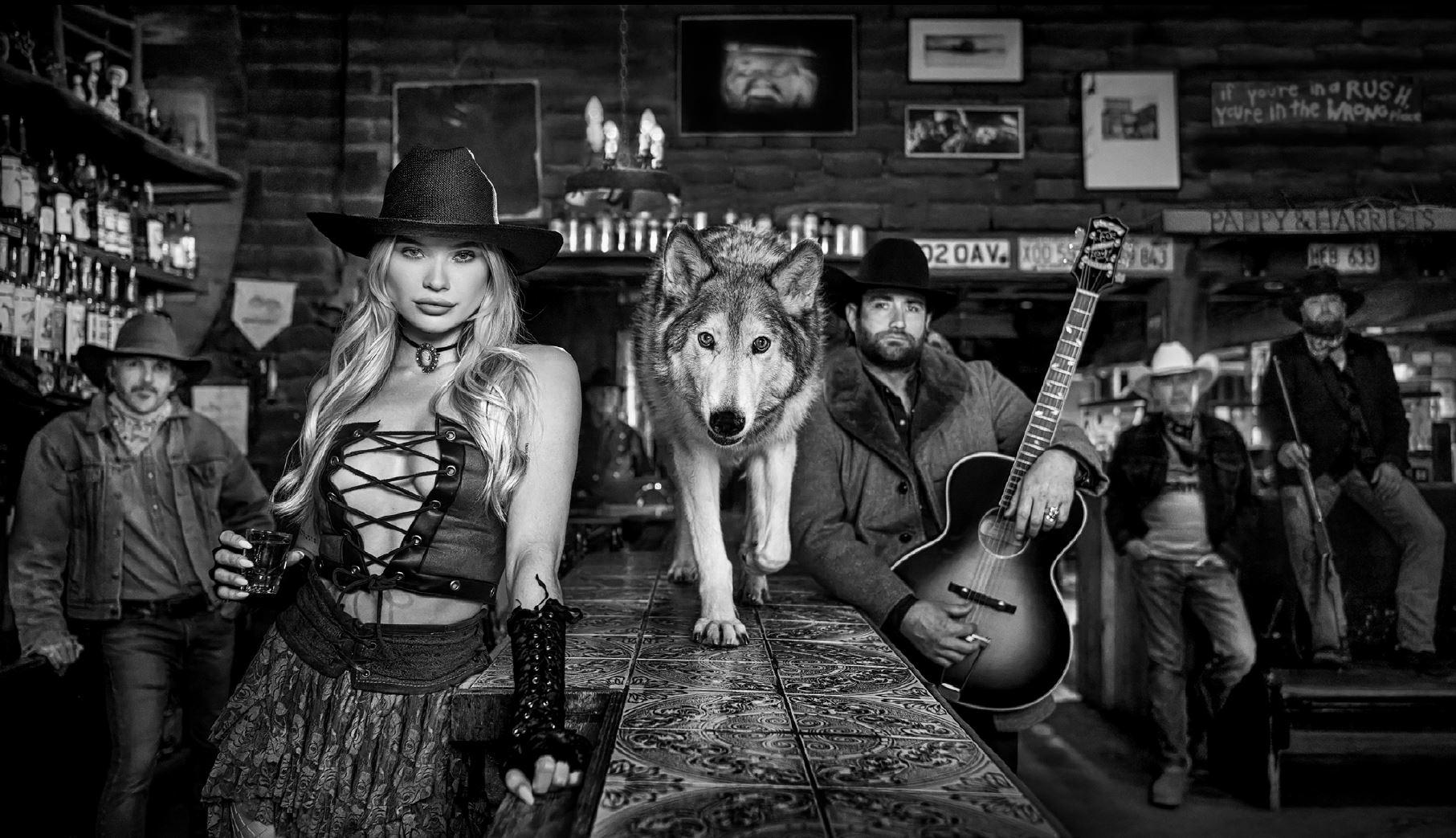 David Yarrow Black and White Photograph - Pappy & Harriet's - Model and Wolf in old Bar, fine art photography, 2024