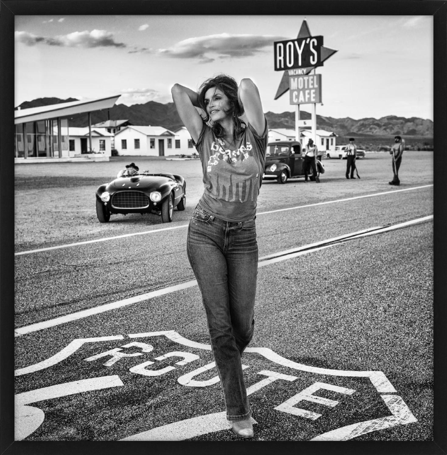 Roy's - Supermodel Cindy Crawford walking in front of 1950s motel on route 66 - Photograph by David Yarrow