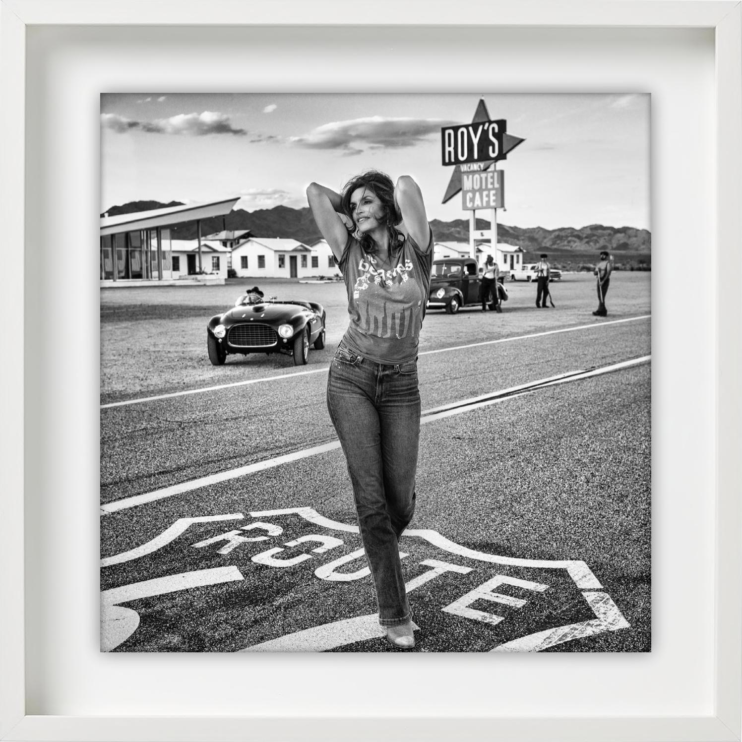 Roy's - Supermodel Cindy Crawford walking in front of 1950s motel on route 66 - Contemporary Photograph by David Yarrow