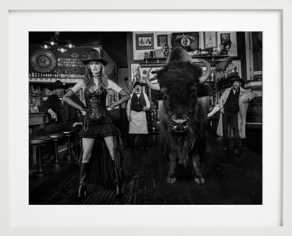 Russische Roulette – Modell und Bison in einer westlichen Bar, Kunstfotografie, 2024 (Zeitgenössisch), Photograph, von David Yarrow