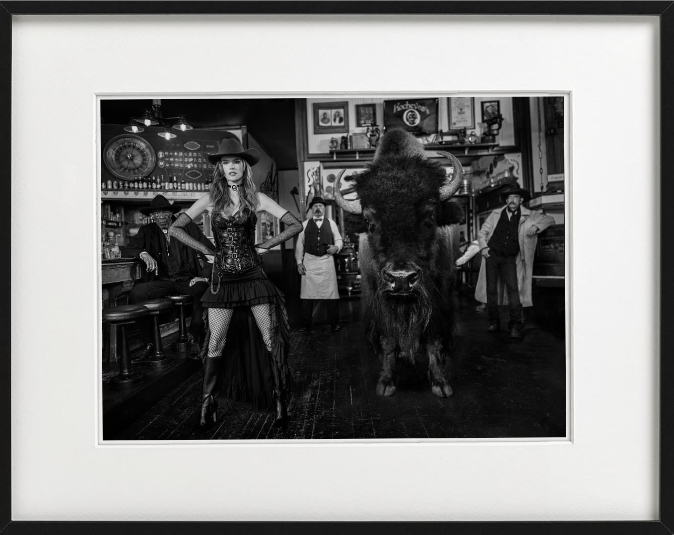 Roulette russe - Modèle et bison dans un bar occidental, photographie d'art, 2024 en vente 1