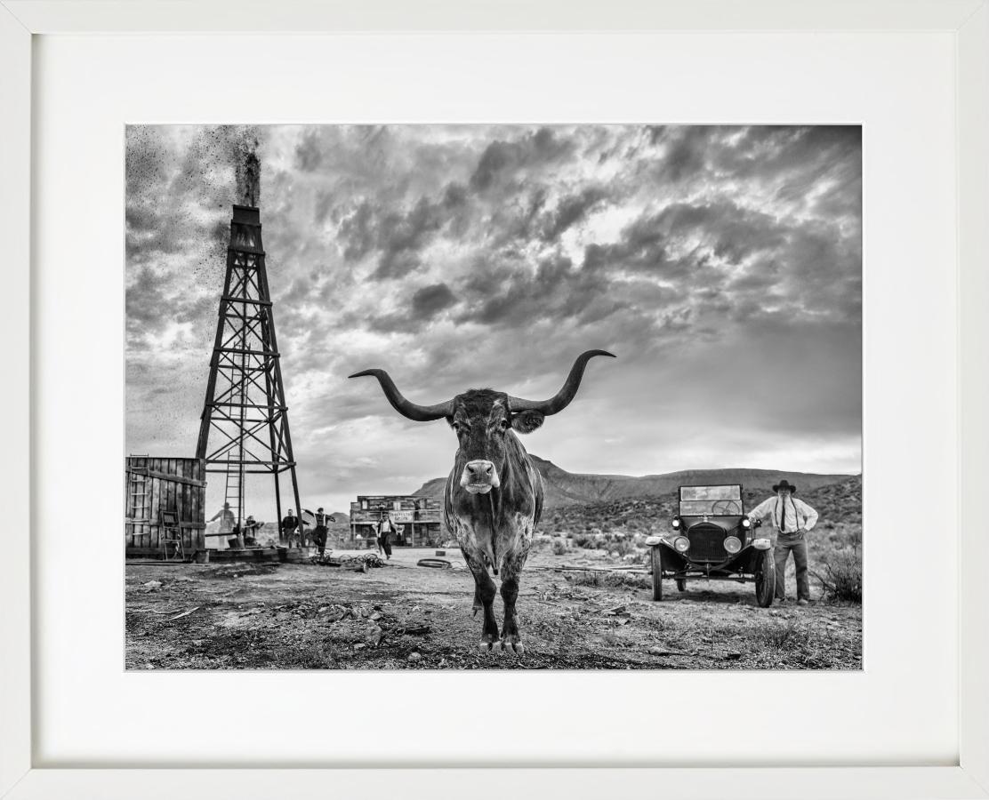 'Texas' - Cow in front of an old Oil derrick, fine art photography, 2023 - Photograph by David Yarrow
