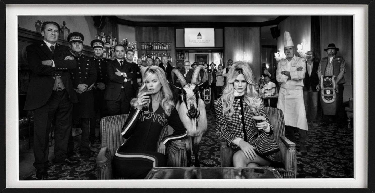 The Goats of St. Moritz - Models with goats and hotel staff sitting in a bar - Photograph by David Yarrow