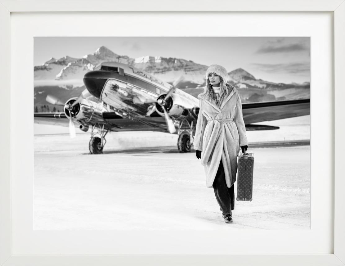 Modèle en manteau et avion Winterwonderland, photographie d'art, 2023 - Photograph de David Yarrow