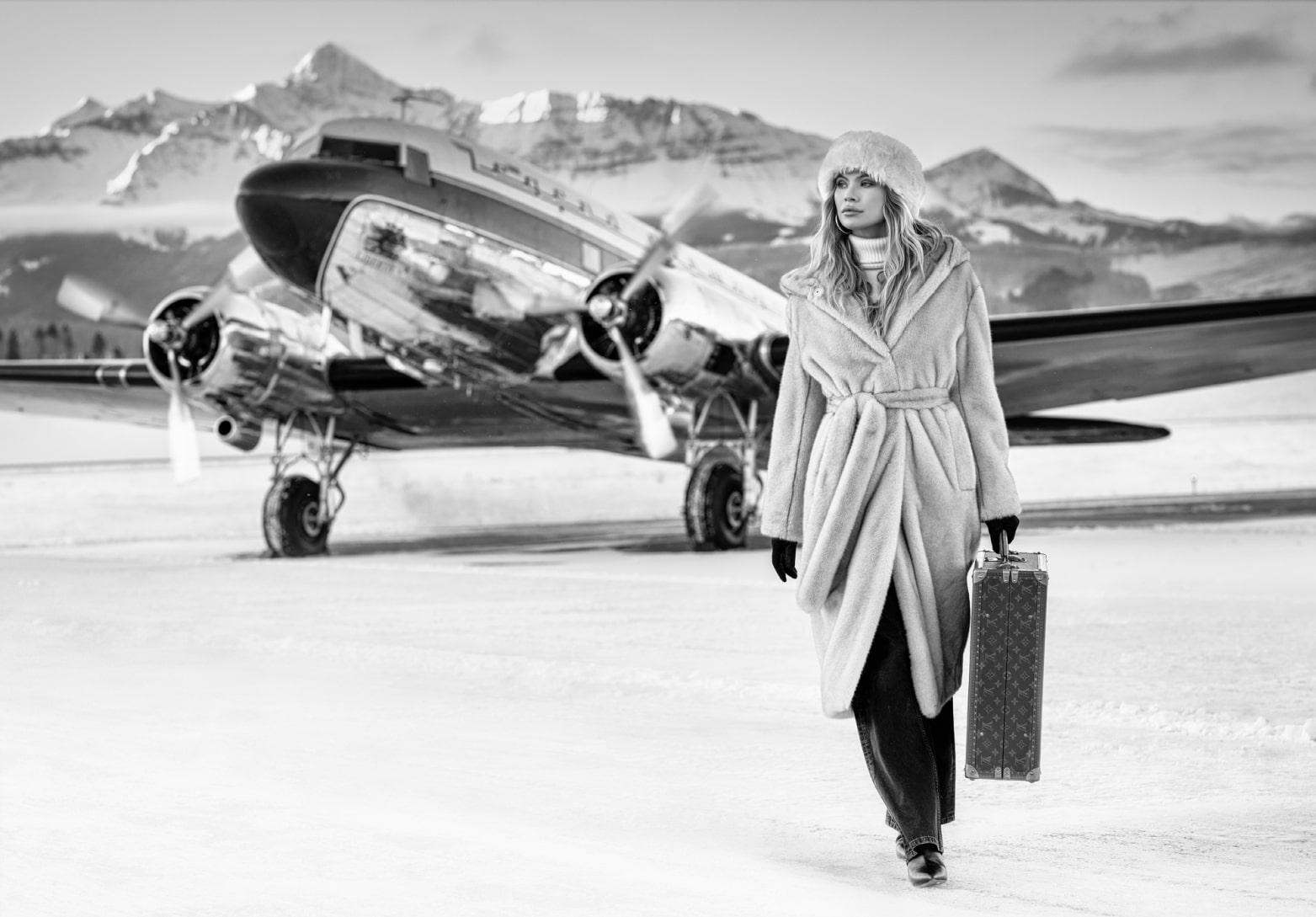 Black and White Photograph David Yarrow - Modèle en manteau et avion Winterwonderland, photographie d'art, 2023