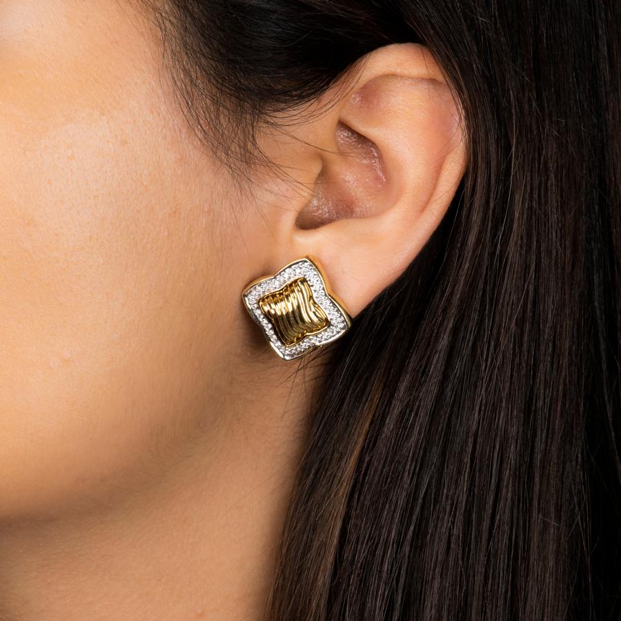 A beautiful pair of earrings by David Yurman from the Quatrefoil collection. They are crafted from 18k yellow gold featuring the quatrefoil shape and cable design set in the center and are bordered by .80 ctw of round diamonds set in white gold