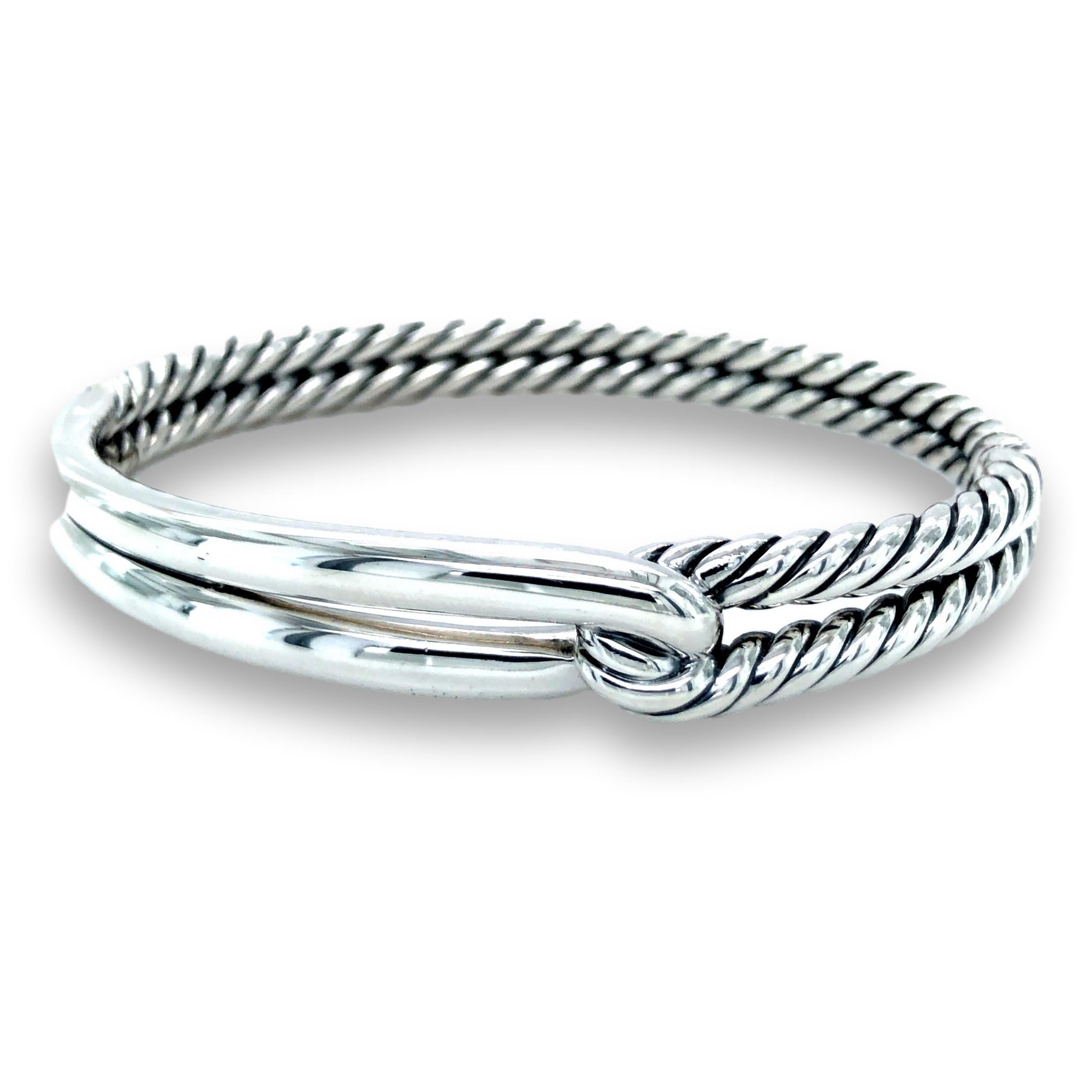 David Yurman single loop bangle bracelet from the labyrinth collection finely crafted in fine sterling silver with a smooth and cable form design with a push button closure. The bracelet is fully hallmarked with logos and metal content. Fits wrists