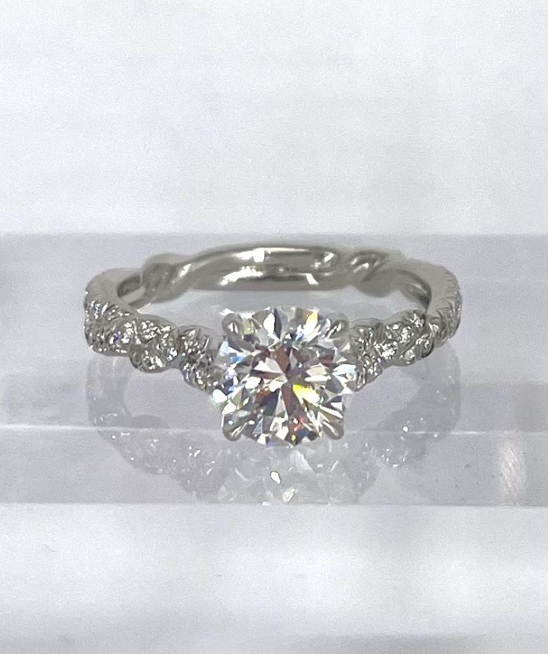This romantic and feminine engagement ring by David Yurman was inspired by interwoven wisteria vines. The center diamond 1.28 carats and certified by GIA to be E color and SI1 clarity. The beautifully crafted interwoven design extends completely