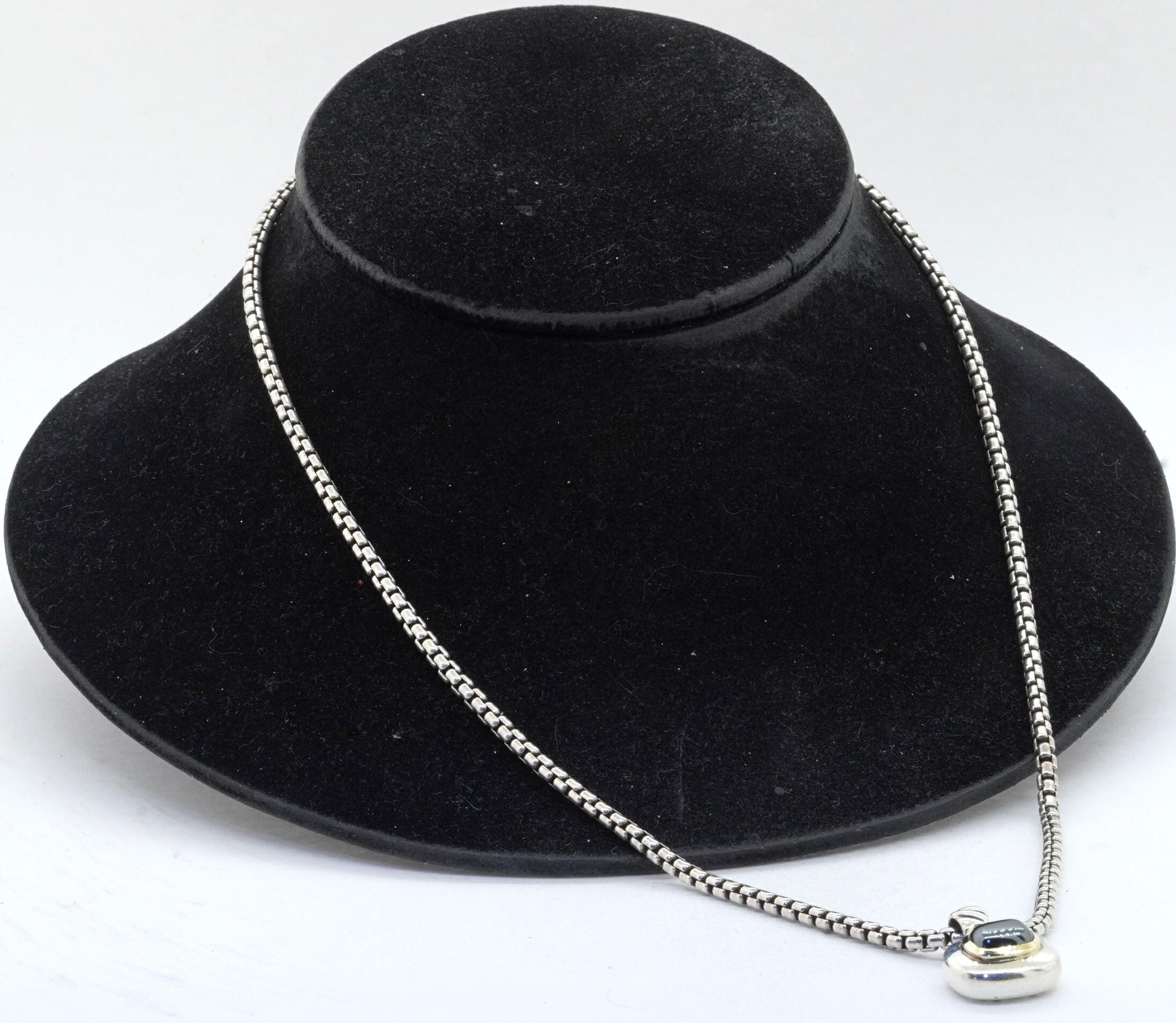 David Yurman 14K & 925 Sterling silver hematite pendant on chain necklace. This intriguing piece of jewelry is crafted in both gorgeous 14K yellow gold/925 Sterling silver and features a genuine approx. 9.4 x 7.2mm hematite. This Cabochon cut gem is