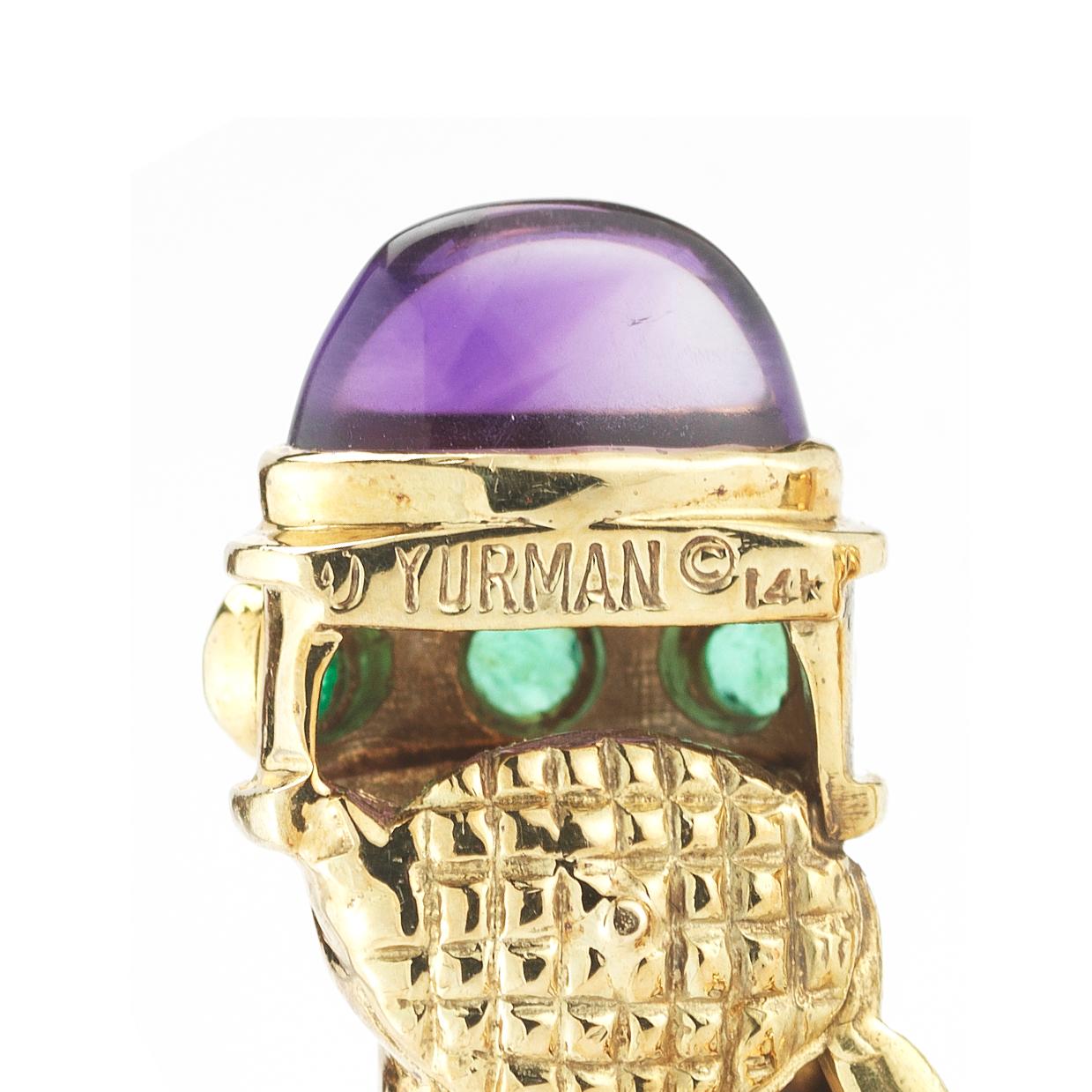 A cornucopia hoop design formed in 14 karat yellow gold features amethyst cabochons totaling approximately 4 carats accented with cabochon emeralds totaling approximately 0.50 carats. Signed Yurman.