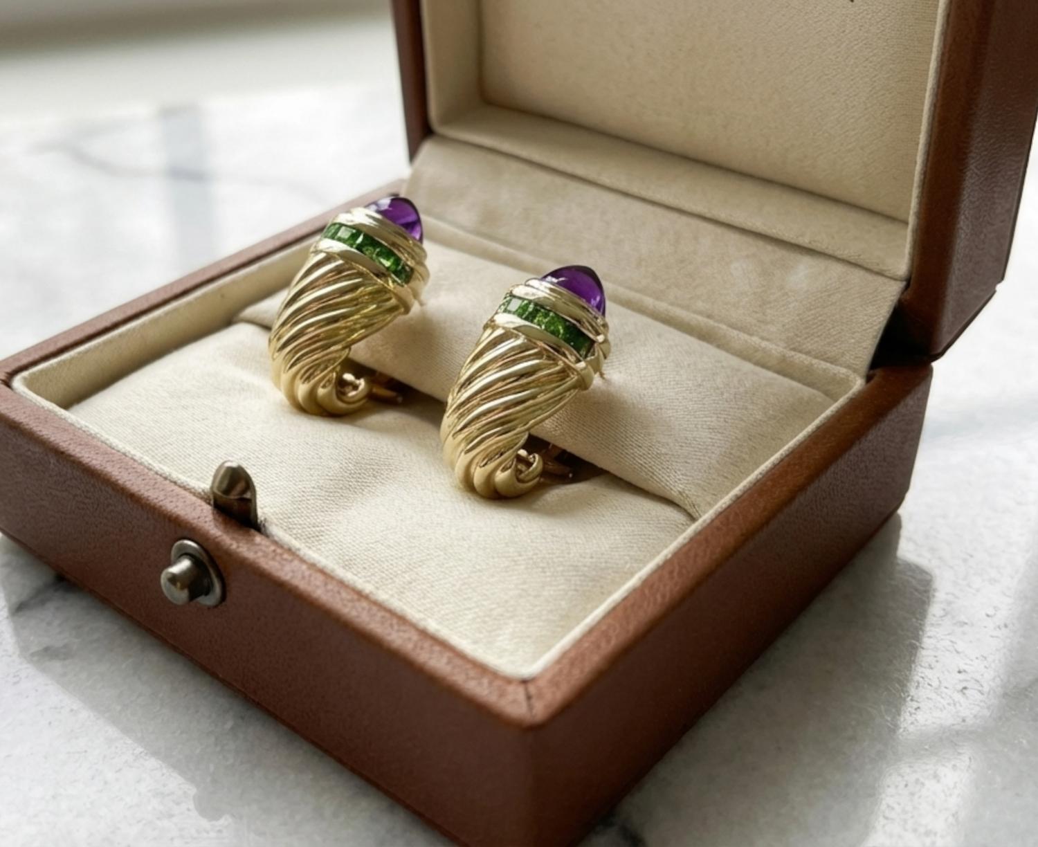 Ces magnifiques boucles d'oreilles David Yurman présentent une combinaison frappante de cabochons d'améthyste naturelle et de grenats richement colorés, sertis dans de l'or jaune 14k chaleureux. Les boucles d'oreilles sont dotées d'un clip raffiné