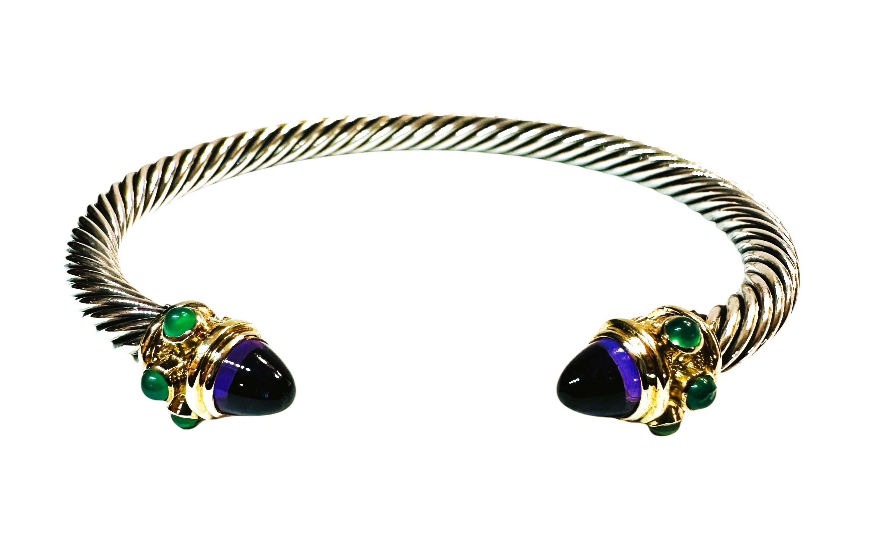This is by David Yurman, an open bangle bracelet from his Renaissance Collection. The sterling silver cable measures 5 mm wide. Each of the 14-karat yellow gold terminals is set with a bullet of cabochon amethyst, and bezel-set around the sides with