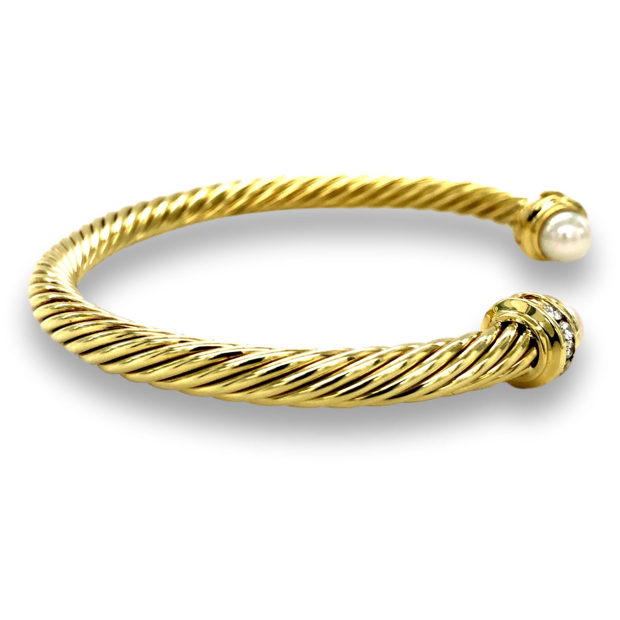 David Yurman open bangle bracelet from the cable collection finely crafted in 18 karat yellow gold featuring two cultured freshwater pearls on each side adorned with pave set round brilliant cut diamond details that weigh 0.22 cts total weight