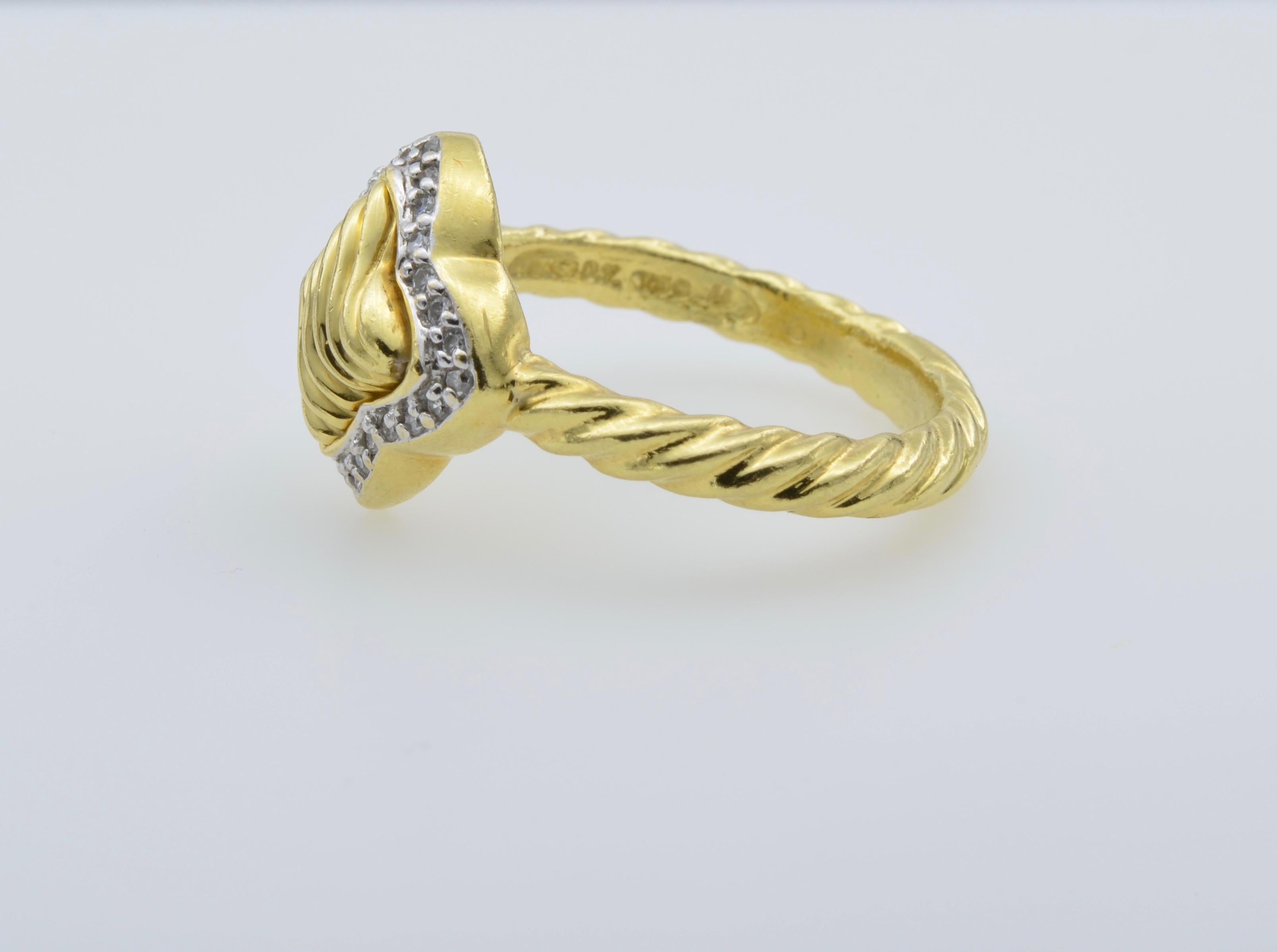 Dieser schöne Ring hat ein charakteristisches Vierblatt-Design. Elegant umrahmt von einer Reihe funkelnder Diamanten, gedrehter Mitte und Band. Der Ring hat die Größe 8 und kann in der Größe angepasst werden.