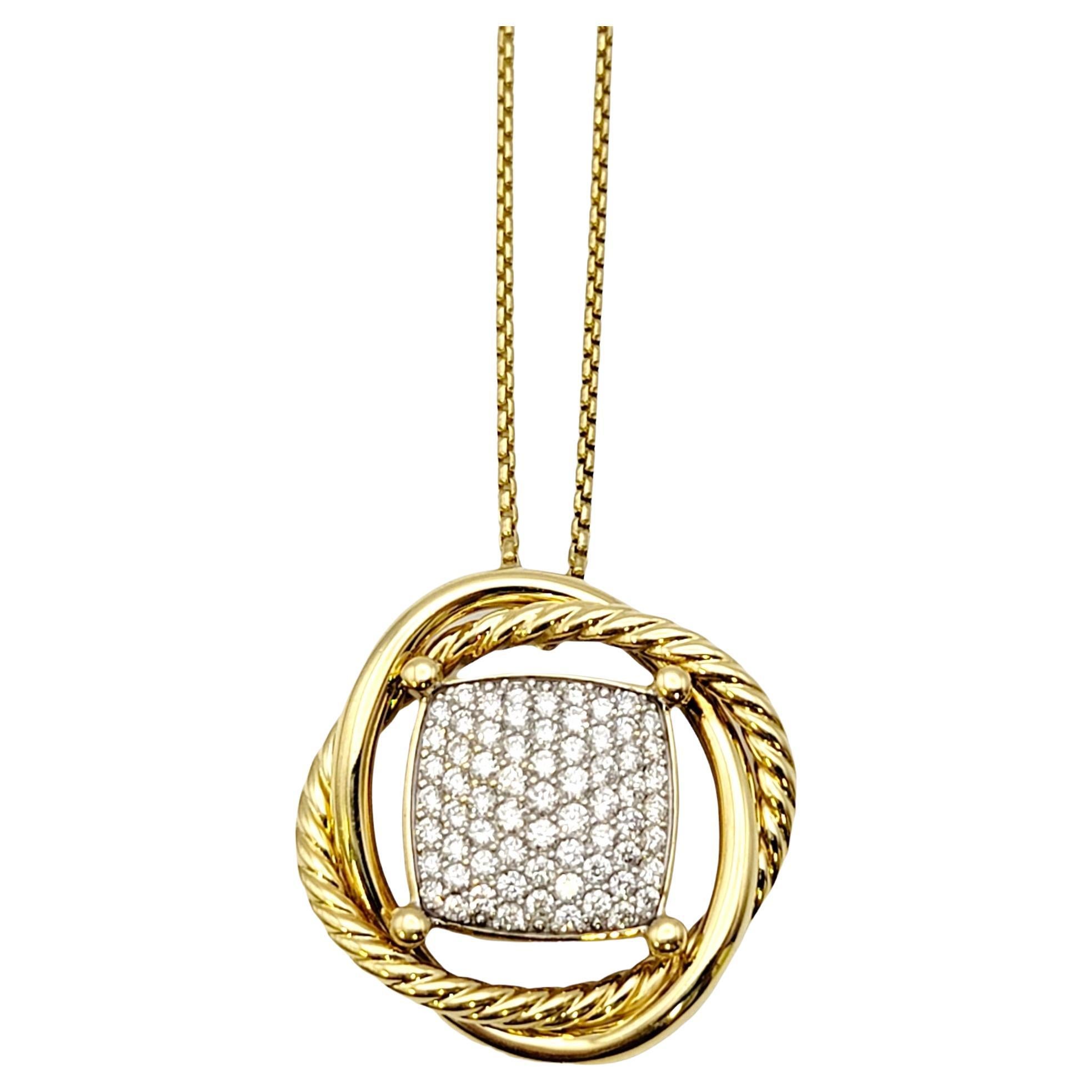 This gorgeous designer necklace by David Yurman features a glittering pave diamond floating square surrounded in polished 18 karat yellow gold. The overlapping plain and cable circle design gently wraps the diamonds, allowing them to sparkle and