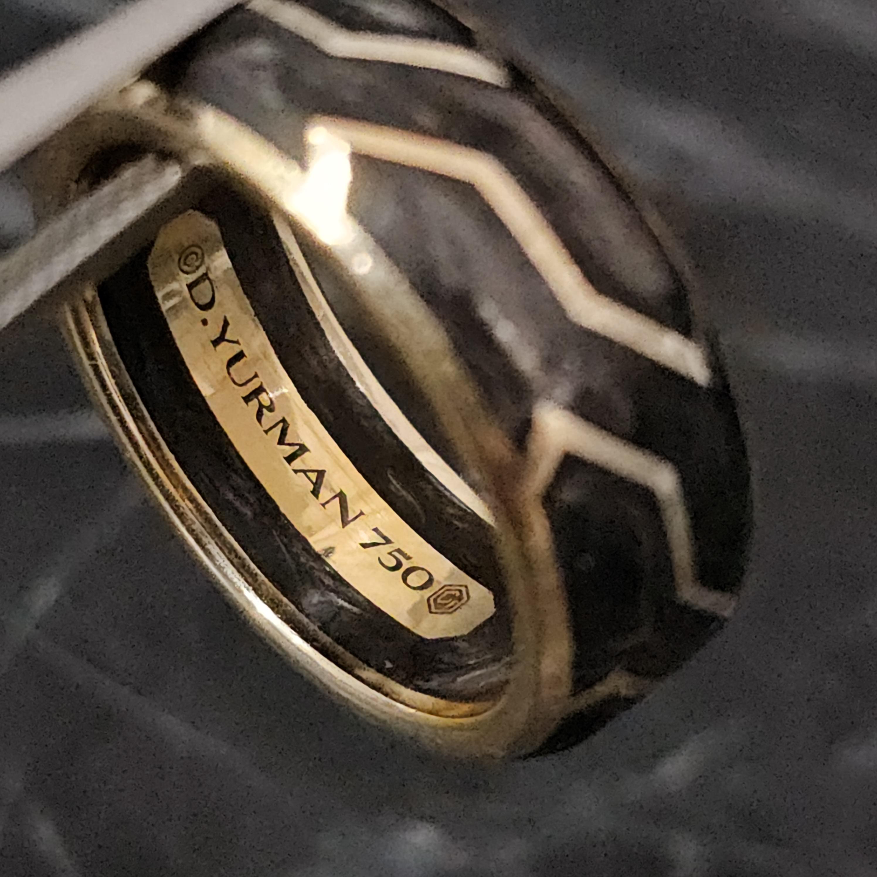 Here we have a David Yurman band ring, featuring a striking design with intricate patterns in forged carbon and 18k yellow gold. The ring is solid and well-crafted, perfect for a wedding or as a statement piece.

Specifics
- Measurements: Ring size