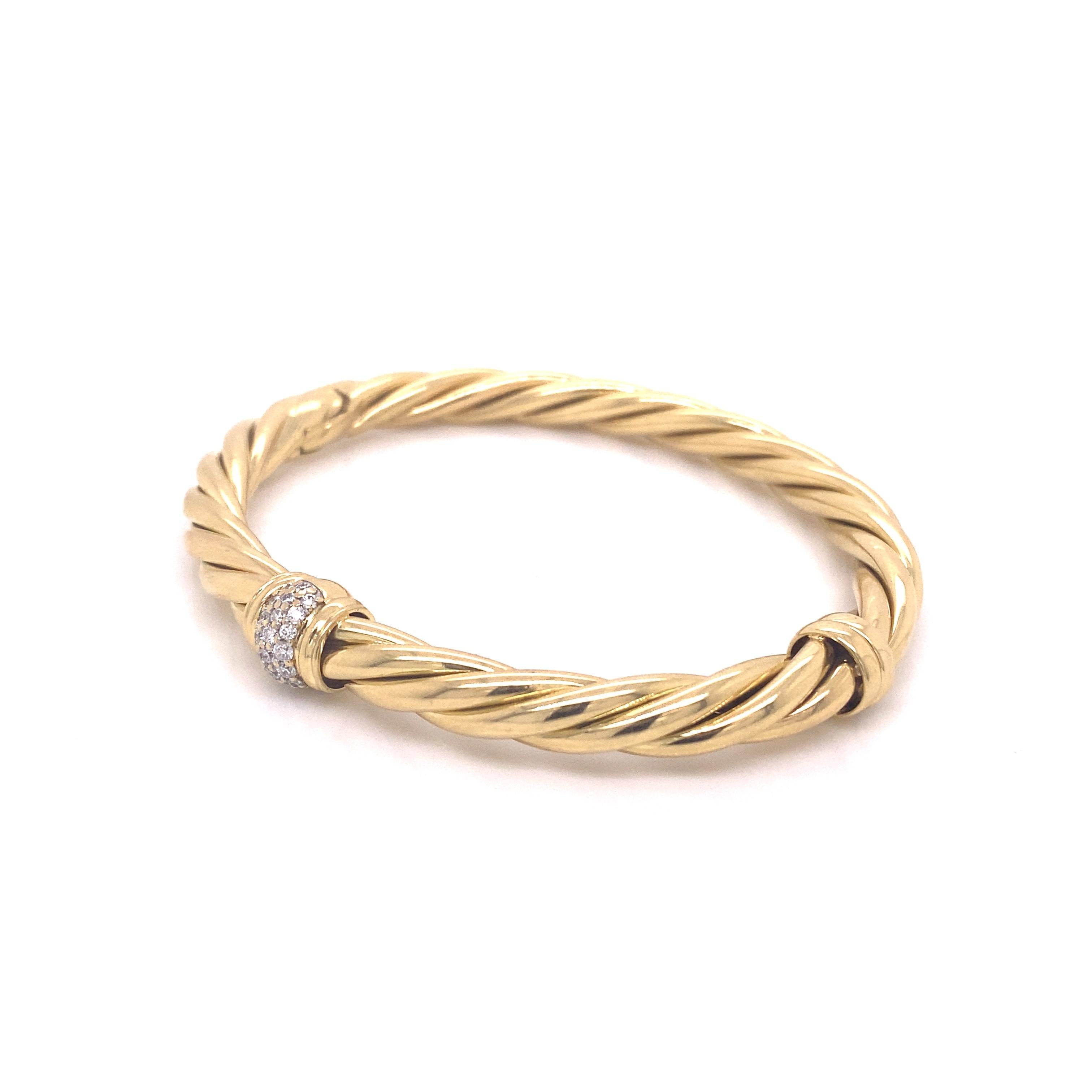 This classic cable bracelet from David Yurman is crafted from 18 karat yellow gold and features a .37ctw pave station at the center with a hinge closure. This is a size medium and will fit up to a 6.5