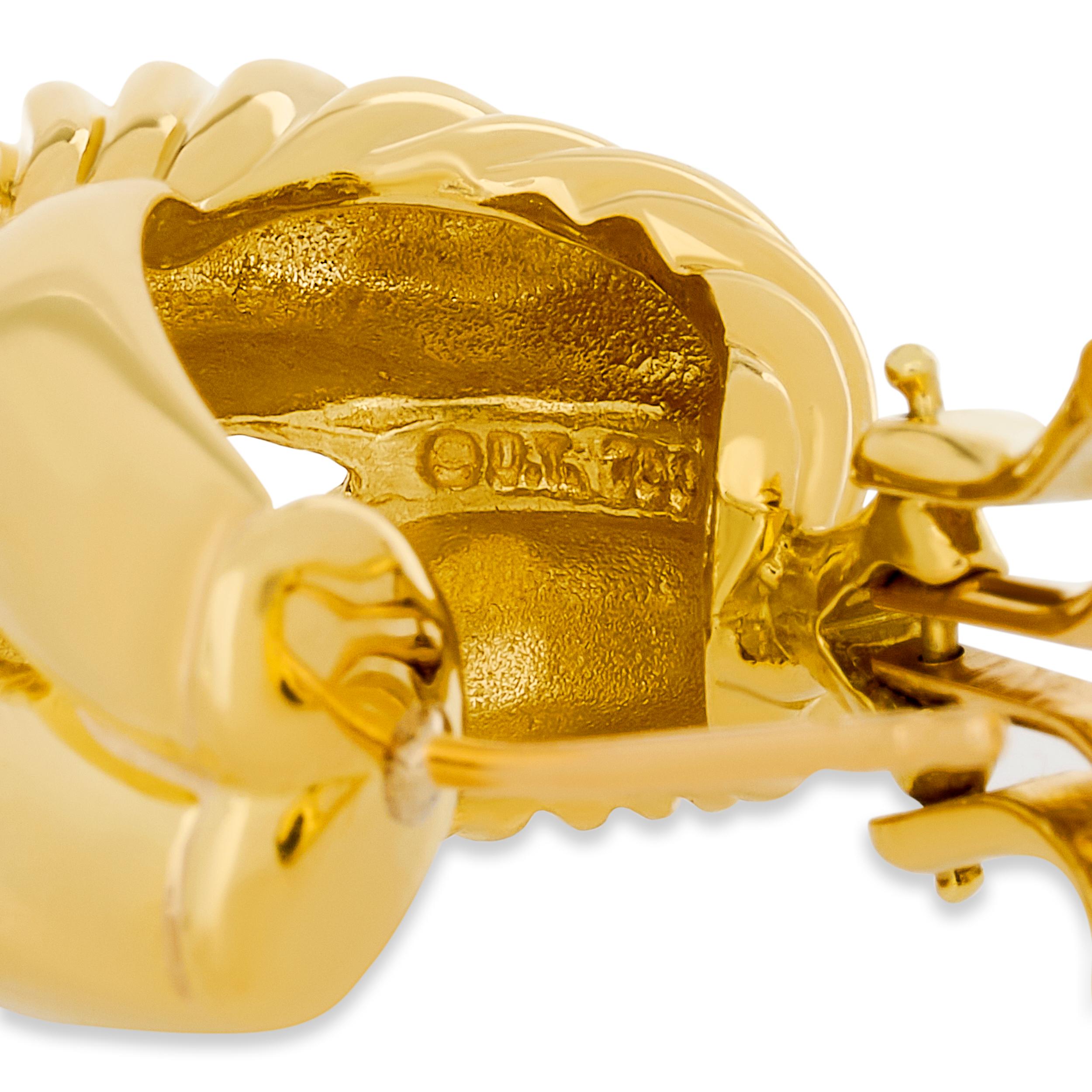 Ces boucles d'oreilles David Yurman présentent un anneau en or jaune, sculpté de manière complexe avec le motif de câble torsadé ou ondulé caractéristique de la marque.

Estampillé 