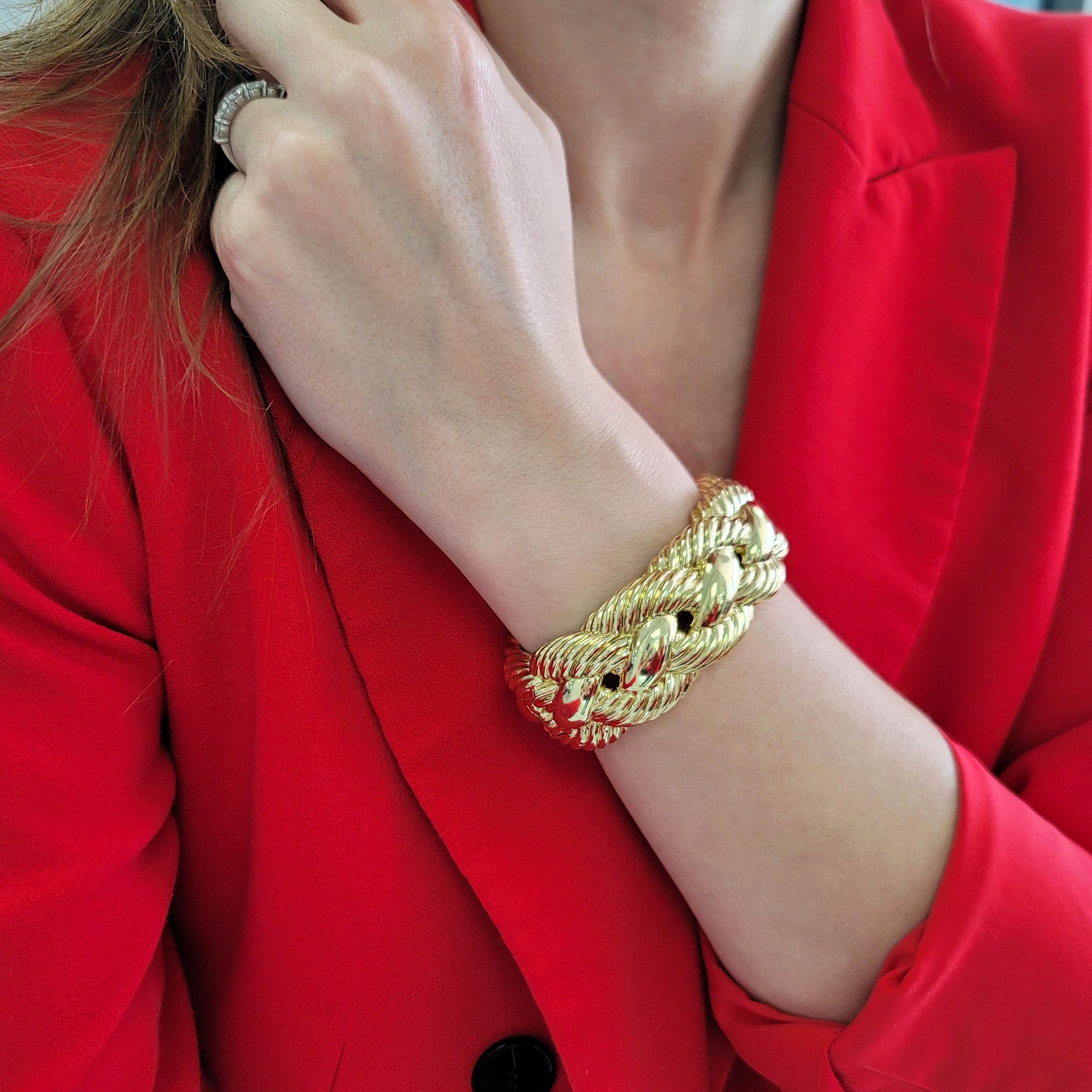 David Yurman 18k Yellow Gold Wide Woven Cable Cuff Bracelet. 
The braclet features braided cable design. Equipped with hinged spring opening. Inscribed: David Yurman, 750, Stainless Steel. Width: Approx. 27mm. Height: Approx. 11mm. Inside diameter: