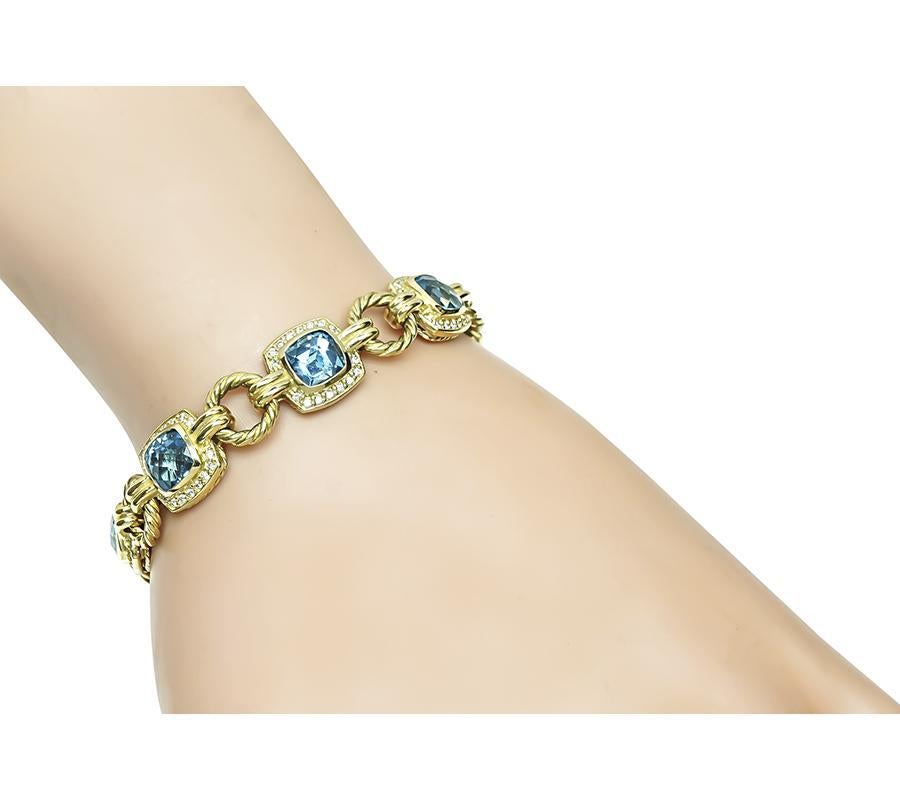 Questo è un affascinante bracciale in oro giallo 18 carati di David Yurman. Il bracciale è incastonato con deliziosi topazi blu taglio cuscino che pesano circa 21,00ct. I topazi sono accentuati da scintillanti diamanti taglio rotondo che pesano