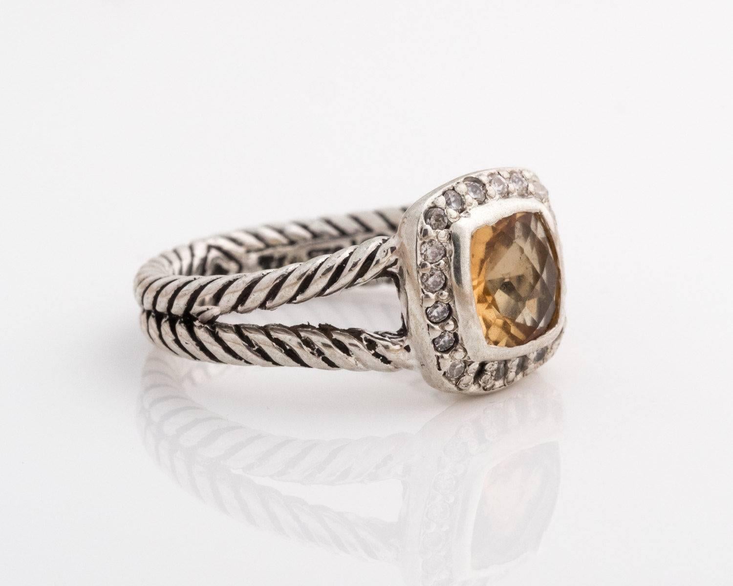 David Yurman Albion Ring - Sterling Silver, Citrine, Diamonds

Features a faceted square cut Citrine surrounded by a halo of diamonds. All of the gems are set in bezel frames. The Yurman cable ring has split shoulders. The cables meet halfway around