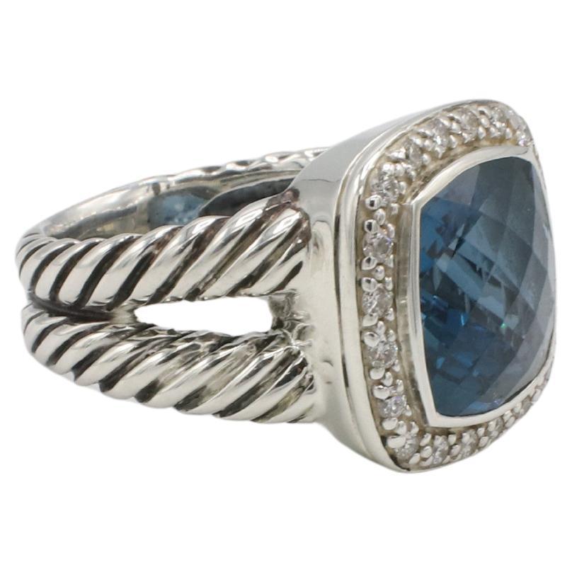 David Yurman Albion Sterling Silber London Blau Topas Natürlicher Diamant Halo Ring 
Metall: Sterling Silber 925
Gewicht: 8.44 Gramm
Größe: 6 (US)
Topas: 11mm
Diamanten: Ca. 0.20 CTW G-H VS-SI runde Naturdiamanten
RLT F35000943